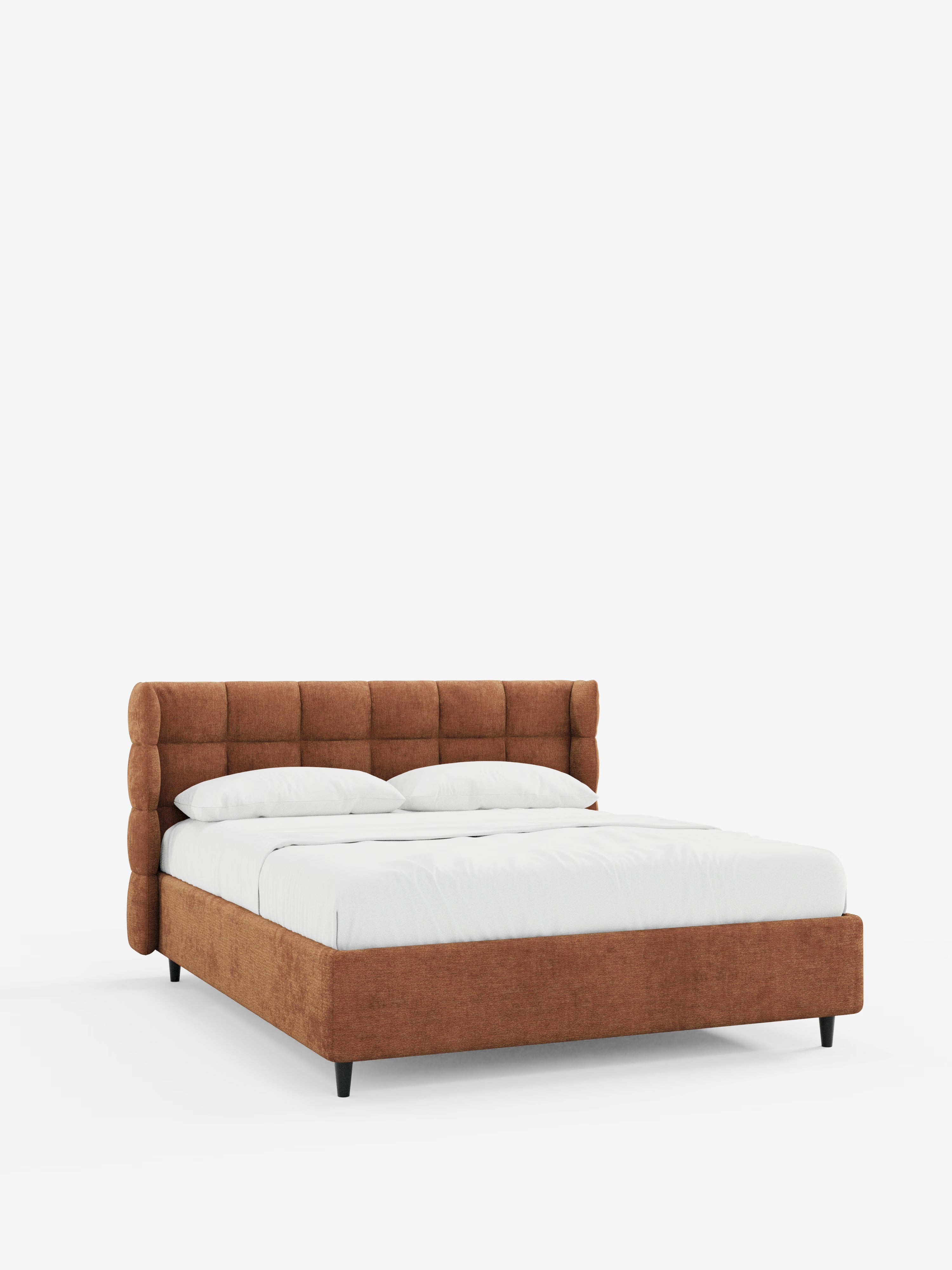 Il letto imbottito RAGNAR con contenitore e testiera capitonné avvolgente di Letti.store presenta una struttura imbottita color ruggine rivestita in un elegante tessuto certificato Oeko-Tex®, una testiera arrotondata capitonné, gambe basse nere e biancheria da letto bianca con due cuscini, il tutto su uno sfondo bianco a tinta unita.