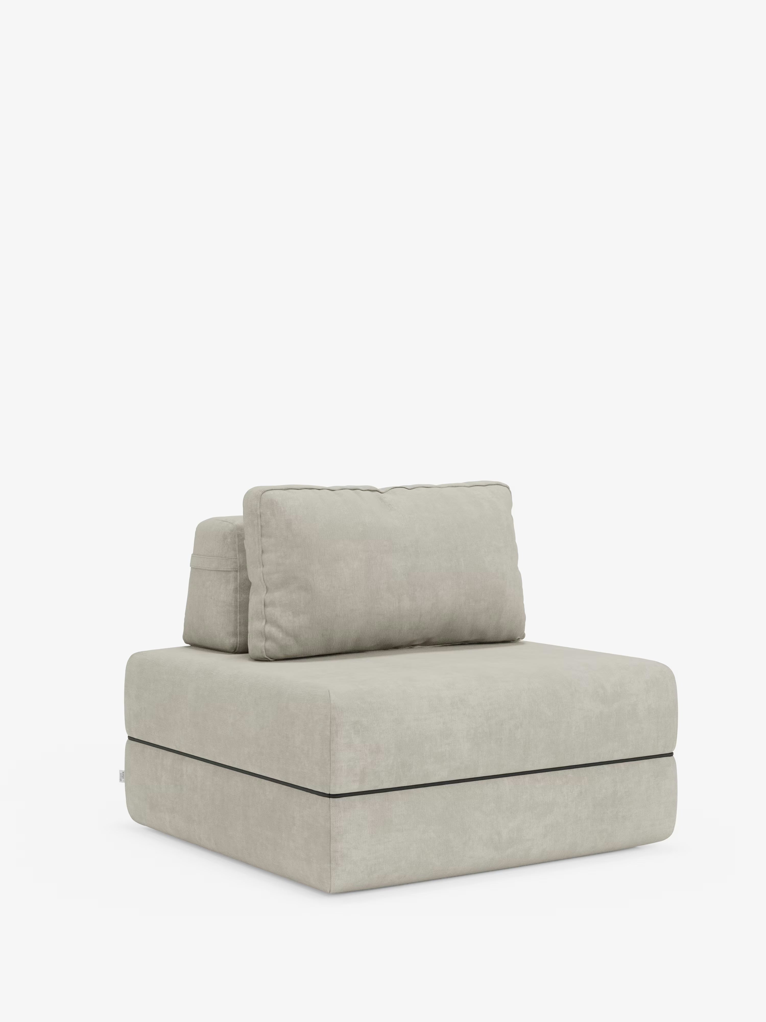Una poltrona modulare Divani.Store color beige chiaro, senza braccioli — denominata “Rift”, poltrona letto con materasso alto 24 cm e memory foam — presenta un morbido cuscino dello schienale rimovibile e si distingue su uno sfondo bianco. Caratterizzata da un design moderno e squadrato, con un rivestimento in T31 morbido e resistente alle macchie e linee pulite, questa poltrona incarna alla perfezione la versatilità minimalista e lo stile contemporaneo.