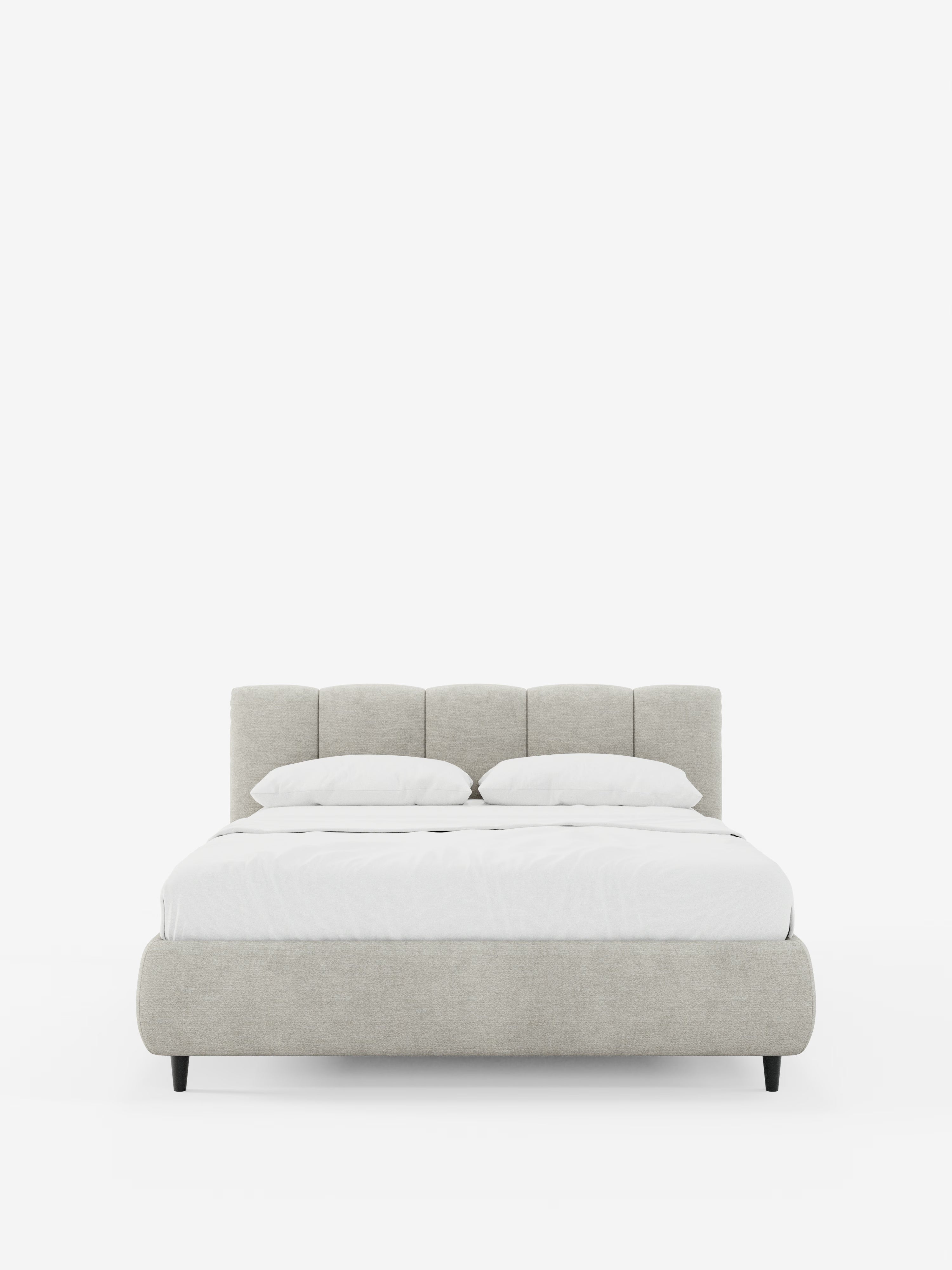 Vista frontale del letto imbottito ARKAM con contenitore e testiera a lavorazione verticale di Letti.store, caratterizzato da un design moderno in stile shabby chic nei toni del grigio chiaro, realizzato in tessuto certificato Oeko-Tex®. Il letto è rifatto con cura con biancheria da letto bianca e due cuscini, poggia su gambe corte e scure e si staglia su uno sfondo bianco a tinta unita.