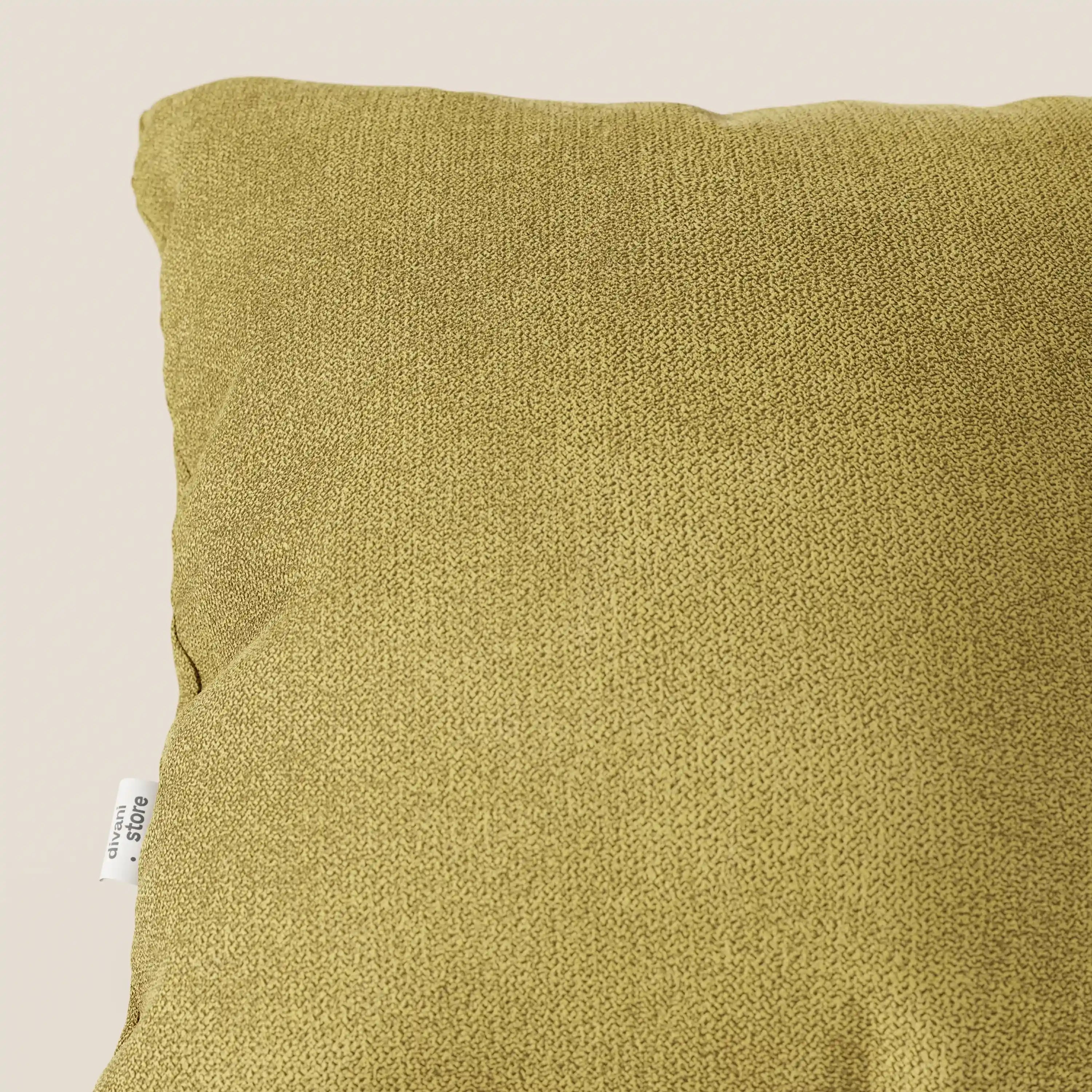 Un primo piano del cuscino Destiny 45x45 cm di Divani.Store, in morbido tessuto impermeabile T02 giallo, mostra il suo tessuto strutturato giallo senape e la piccola etichetta laterale bianca su uno sfondo chiaro e neutro. È visibile solo la parte superiore sinistra.