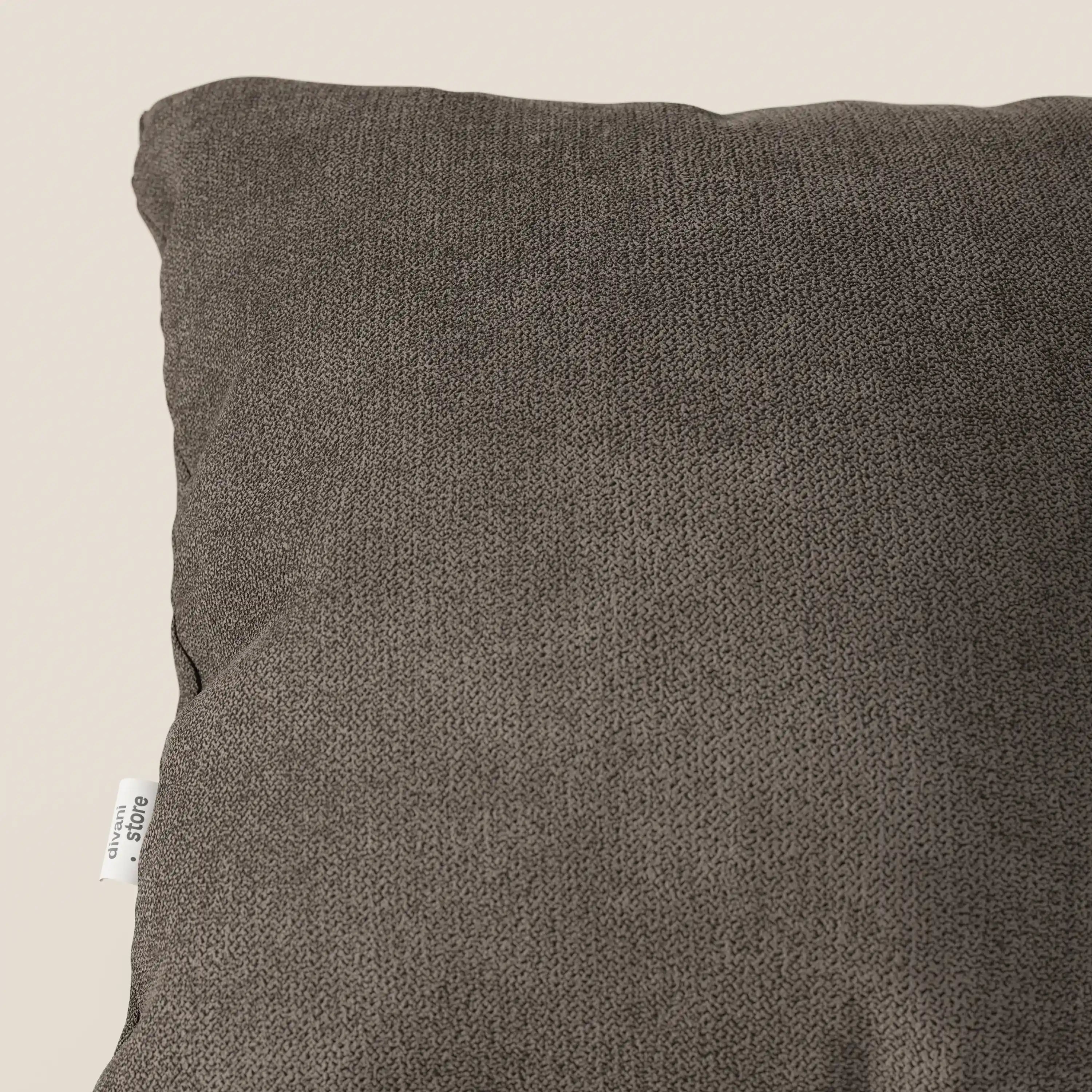 Primo piano del cuscino Destiny di Divani.Store in morbido tessuto impermeabile T02 marrone, su sfondo beige. Sul bordo è visibile una piccola etichetta bianca che ne evidenzia la texture e l'eleganza versatile.