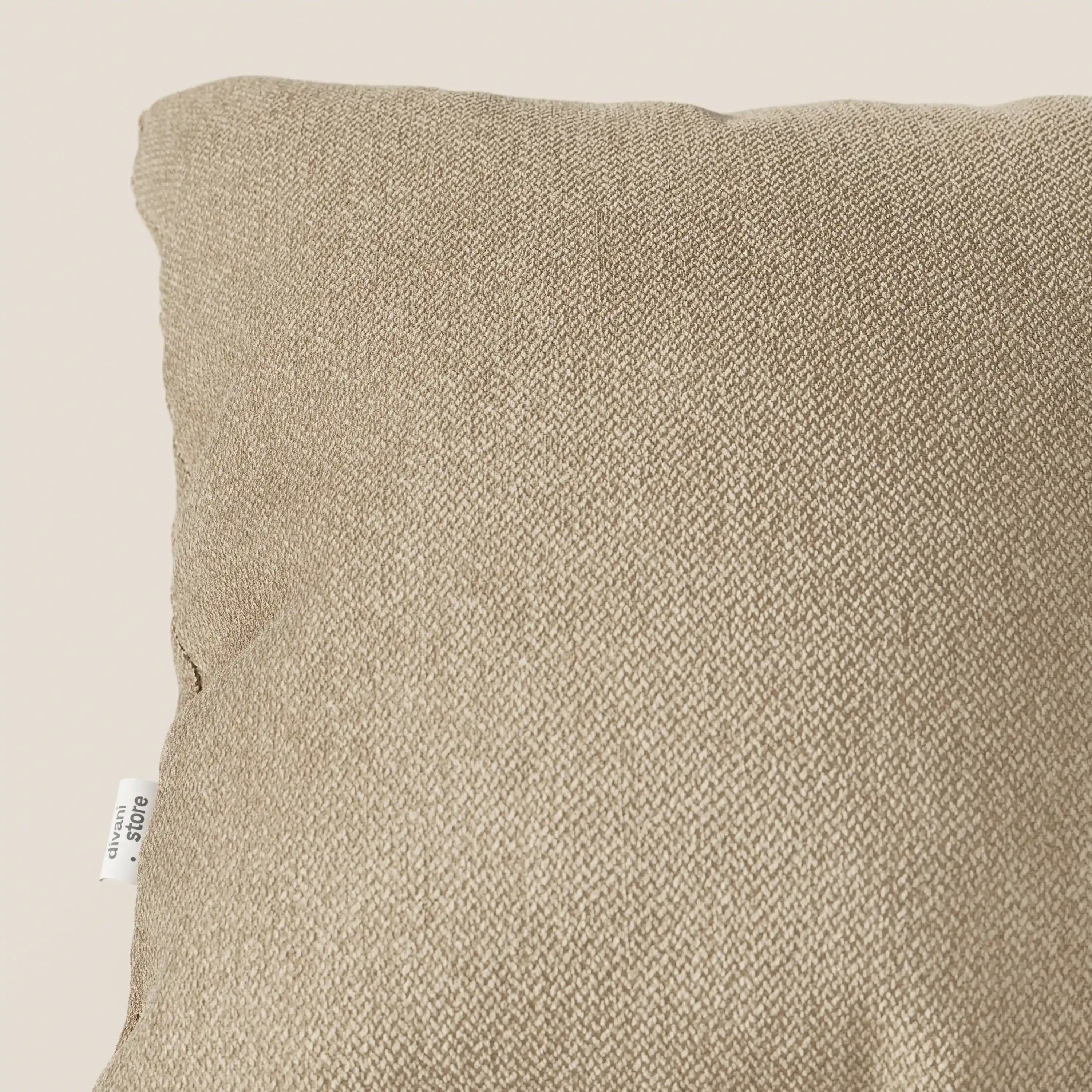Un primo piano dei cuscini Sogno di Divani.Store in morbido tessuto SMACCHIABILE T05 cammello mostra la trama elegante e un'etichetta bianca laterale; perfetto tra i cuscini eleganti per divani. Sfondo color crema chiaro.