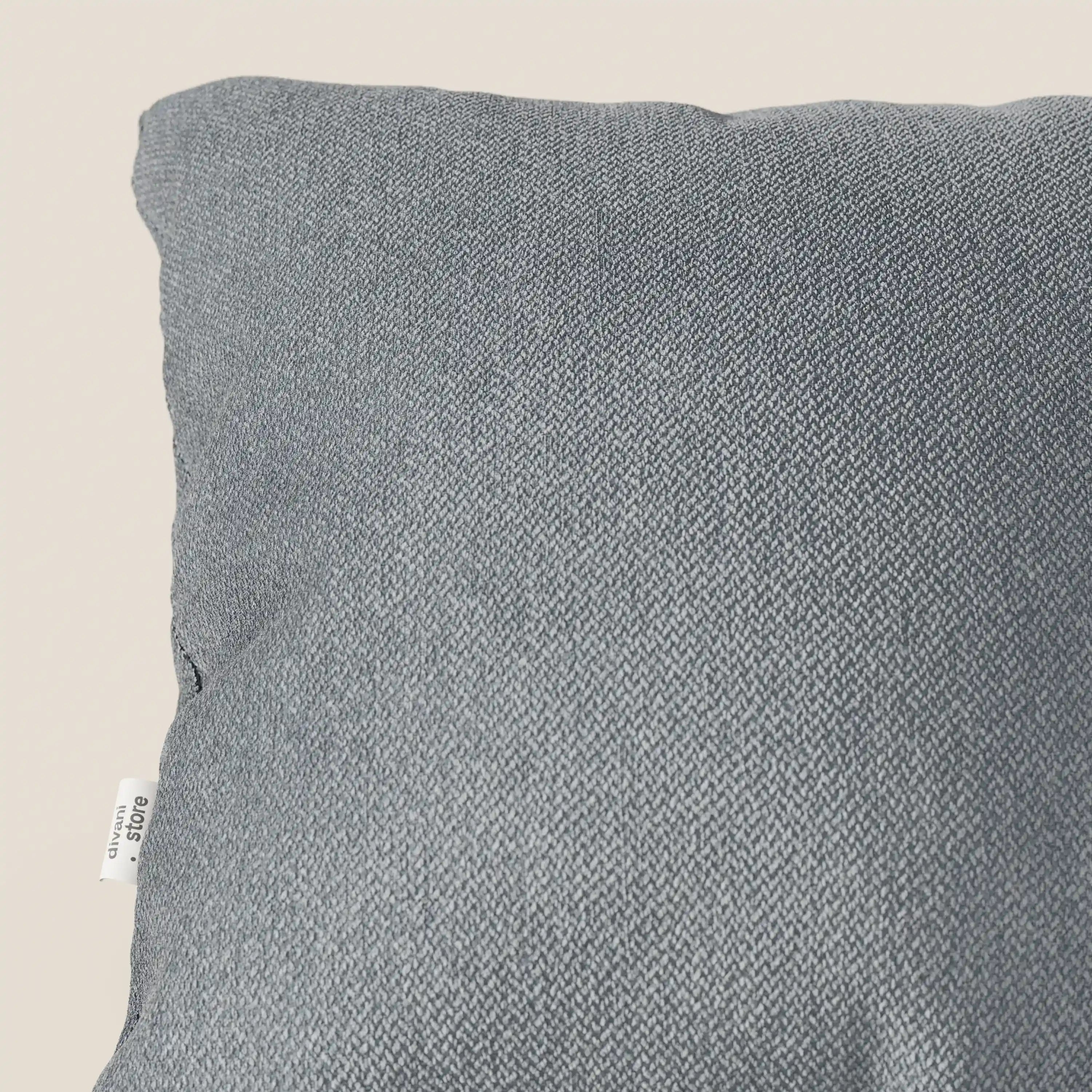 Primo piano del cuscino Sogno di Divani.Store in morbido tessuto smacchiabile T05 carta da zucchero, ideale come cuscino d'arredo per divani. Il piccolo tag bianco e la trama visibile donano eleganza a questo pezzo senza tempo.