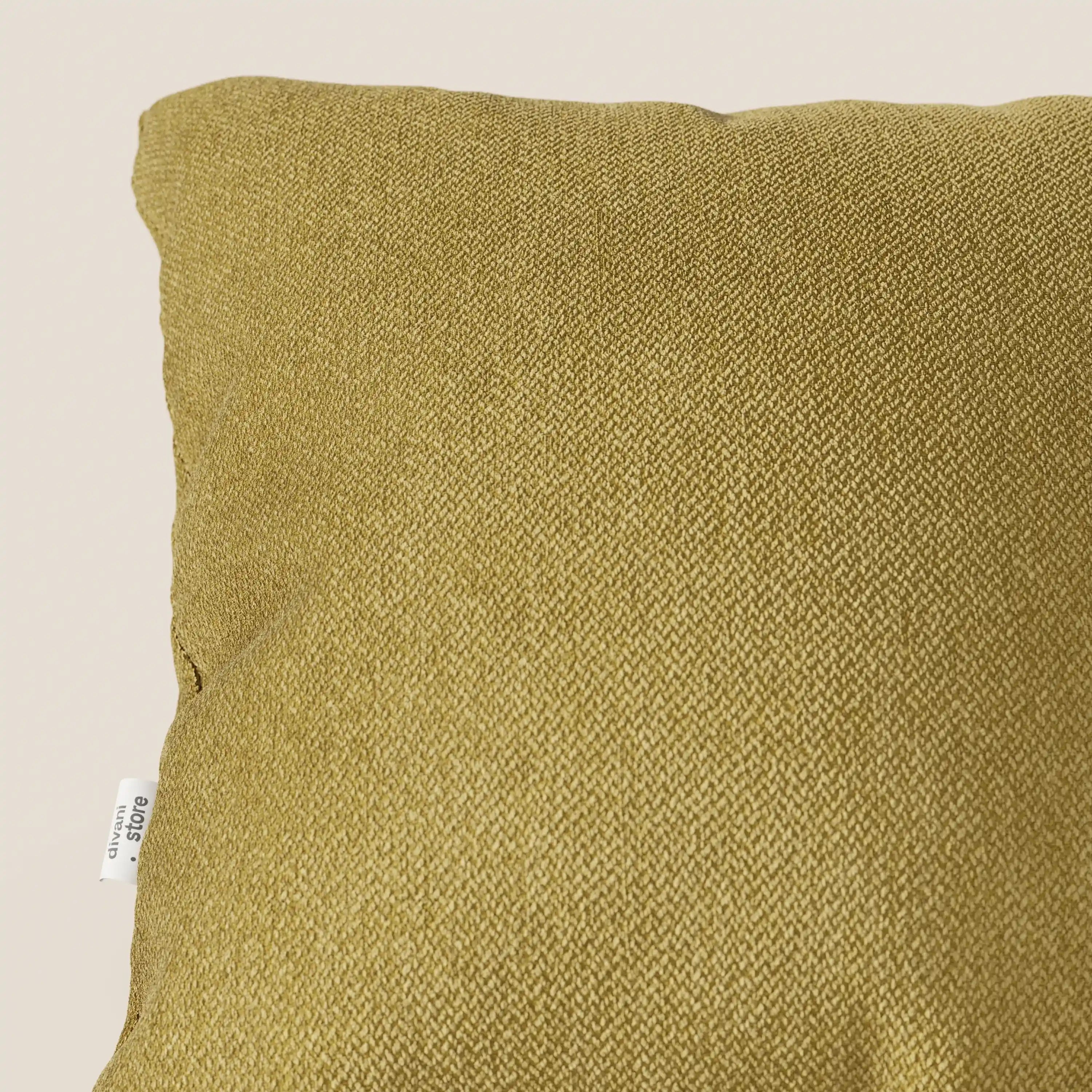 Primo piano del cuscino Sogno di Divani.Store, nel colore SMACCHIABILE T05 giallo, che mette in evidenza il tessuto morbido e strutturato e le cuciture sottili su uno sfondo beige. Sul bordo sinistro è applicata una piccola etichetta bianca.