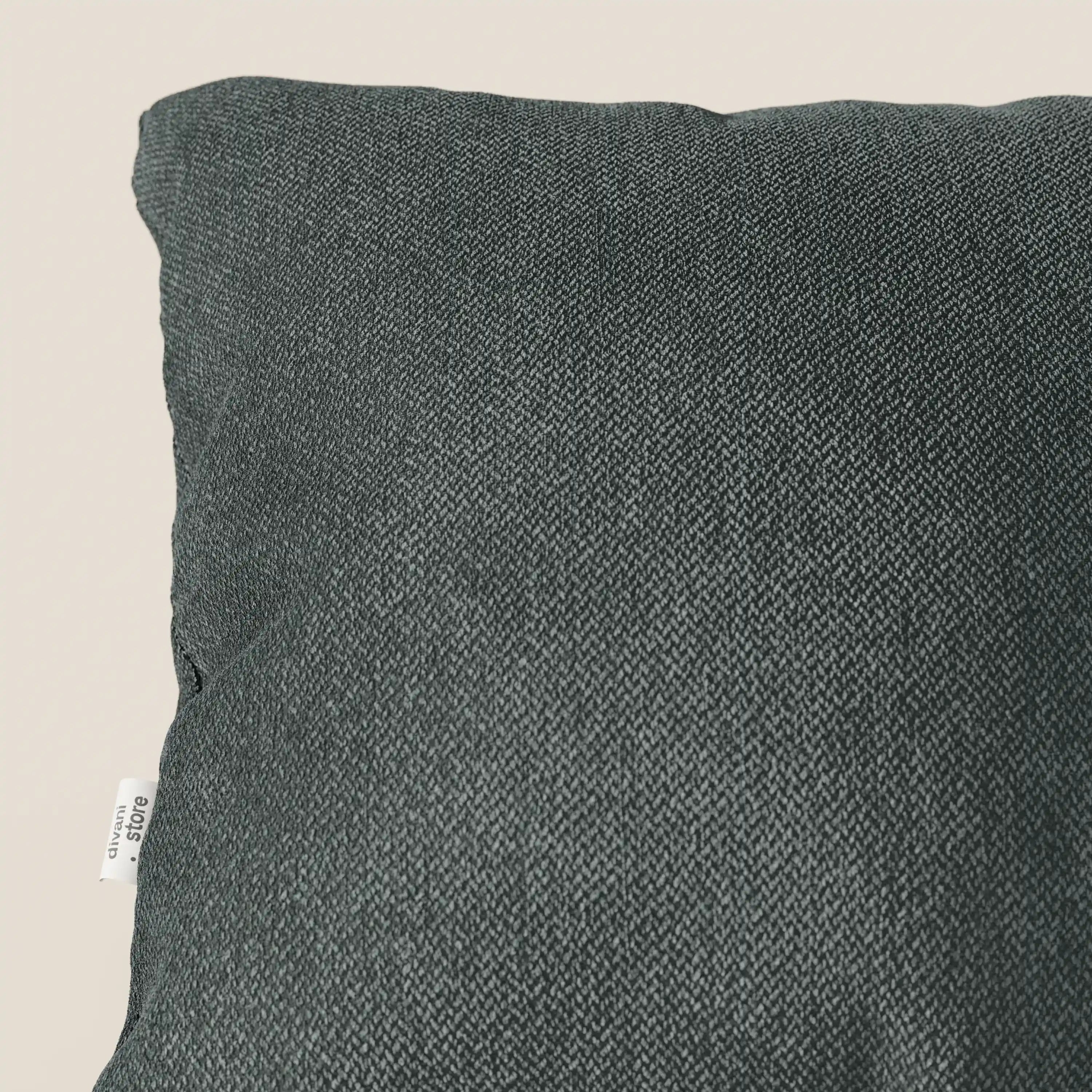 Primo piano di un cuscino Sogno di Divani.Store in morbido tessuto verde T05 antimacchia. L'elegante trama e la piccola etichetta bianca sono visibili, mentre il cuscino occupa la maggior parte dell'immagine su uno sfondo chiaro.