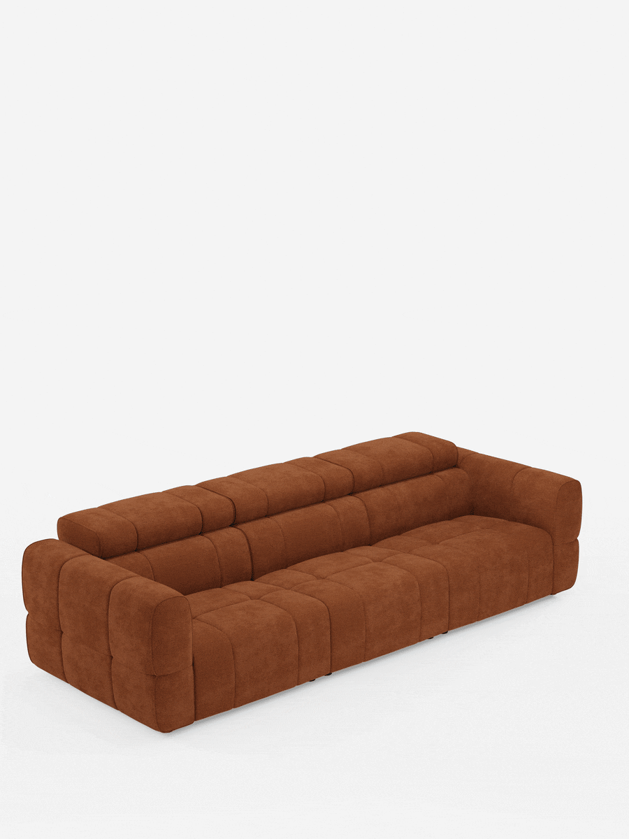 Un divano modulare contemporaneo Giotto a 4 posti con poggiatesta reclinabili e funzione relax elettrica opzionale, rivestito in tessuto smacchiabile T23 color deep rust, caratterizzato da un design a griglia trapuntata dal profilo basso e ampi braccioli su sfondo bianco.