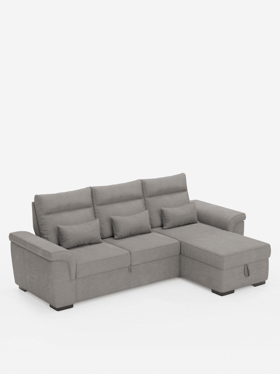 Un divano letto angolare Ischia grigio chiaro con schienali scorrevoli, elemento estraibile e penisola contenitore in tessuto antimacchia misto lino, con chaise longue sul lato destro, tre cuscini dello schienale, tre cuscini lombari, maniglia per il contenitore e piedini a blocco scuri.