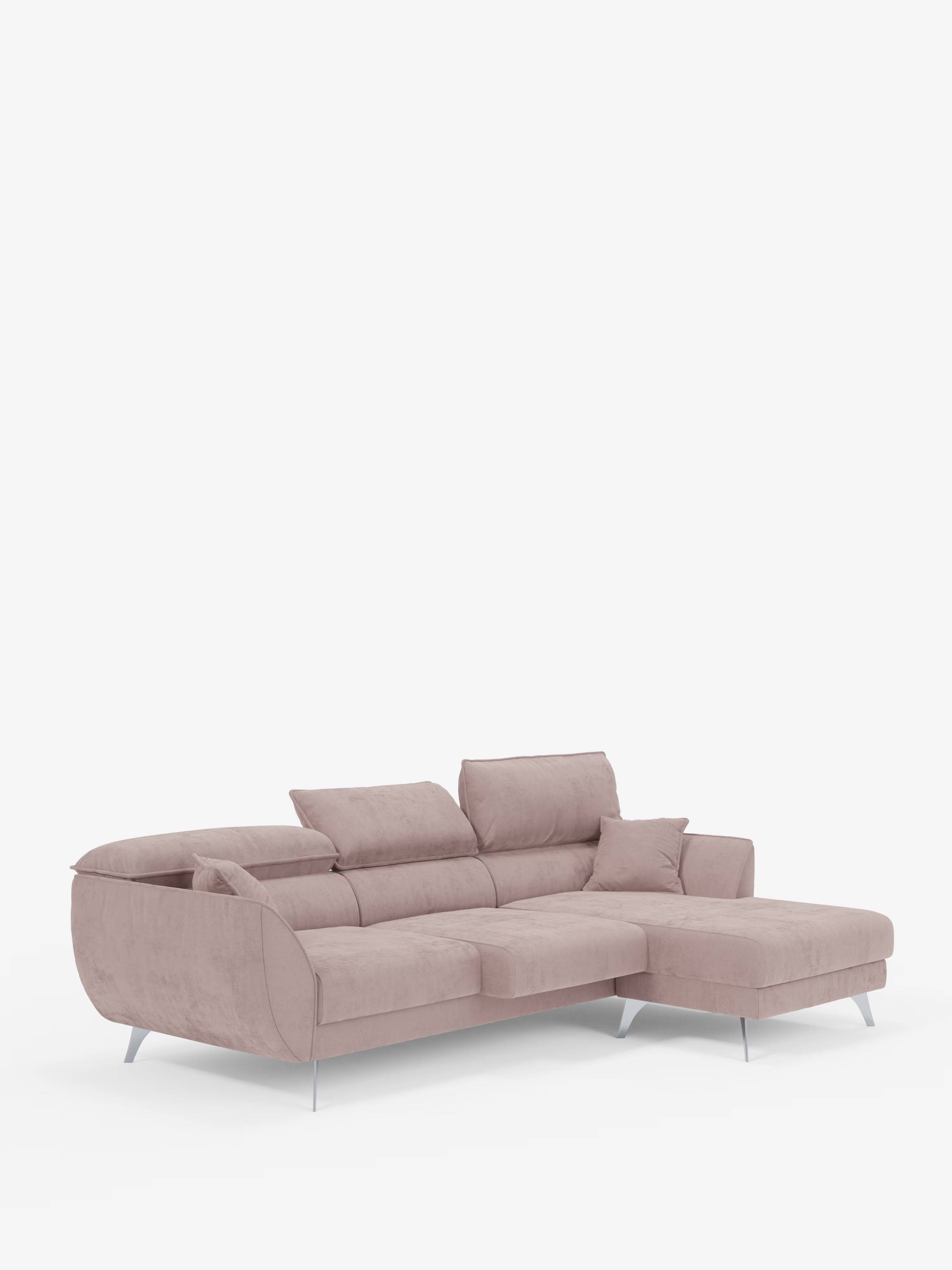 Il divano angolare con penisola e sedute estensibili “Michelangelo” di Divani.Store è un moderno divano componibile a forma di L rivestito in tessuto T30 effetto velluto rosa chiaro e resistente alle macchie. È caratterizzato da eleganti gambe in metallo, tre poggiatesta reclinabili, una chaise longue estesa sul lato destro ed è corredato da un cuscino decorativo coordinato, il tutto presentato su uno sfondo bianco a tinta unita.