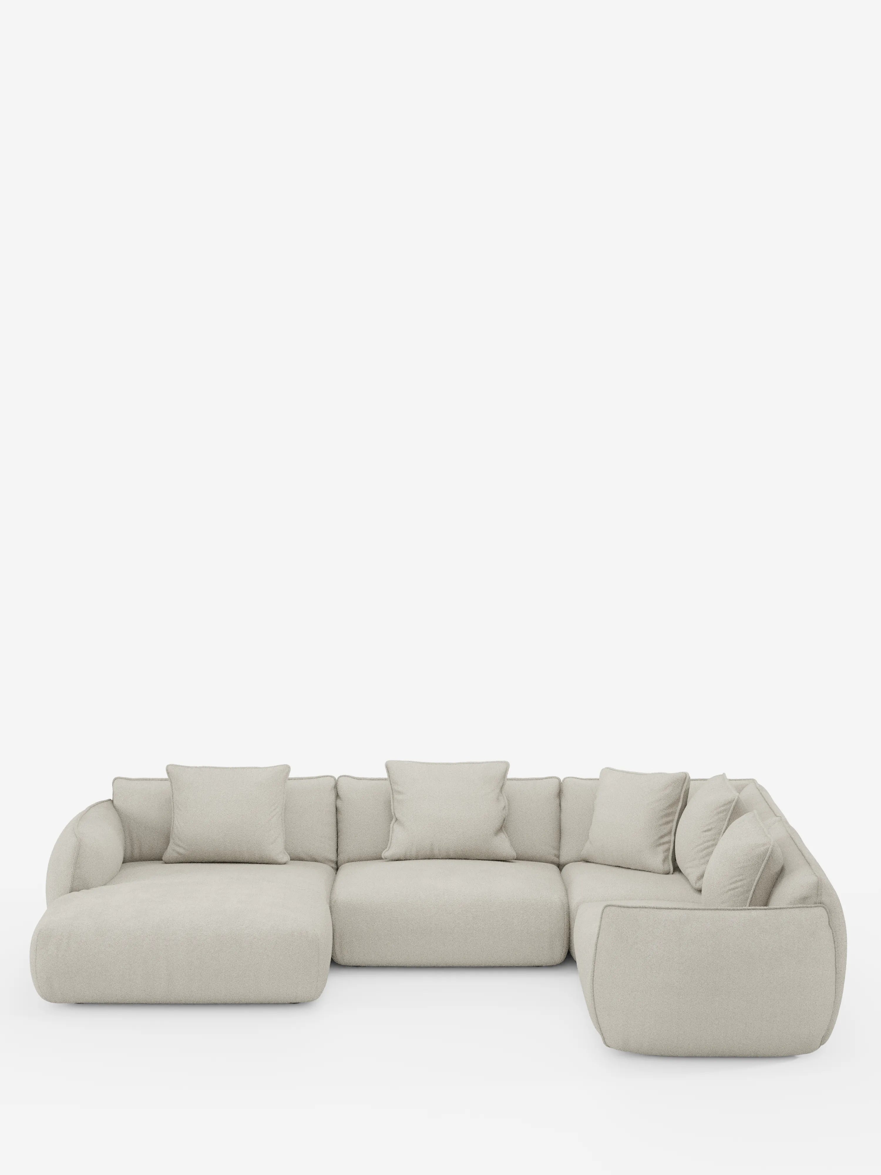 Un divano angolare panoramico componibile Nimbus in beige chiaro, con penisola e angolo in tessuto smacchiabile t33 di Divani.Store, caratterizzato da un design modulare a forma di L con morbidi cuscini e schienali bassi e arrotondati. Realizzato in Italia, comprende tre sezioni di seduta principali e sette cuscini decorativi coordinati, che risaltano su uno sfondo bianco a tinta unita.