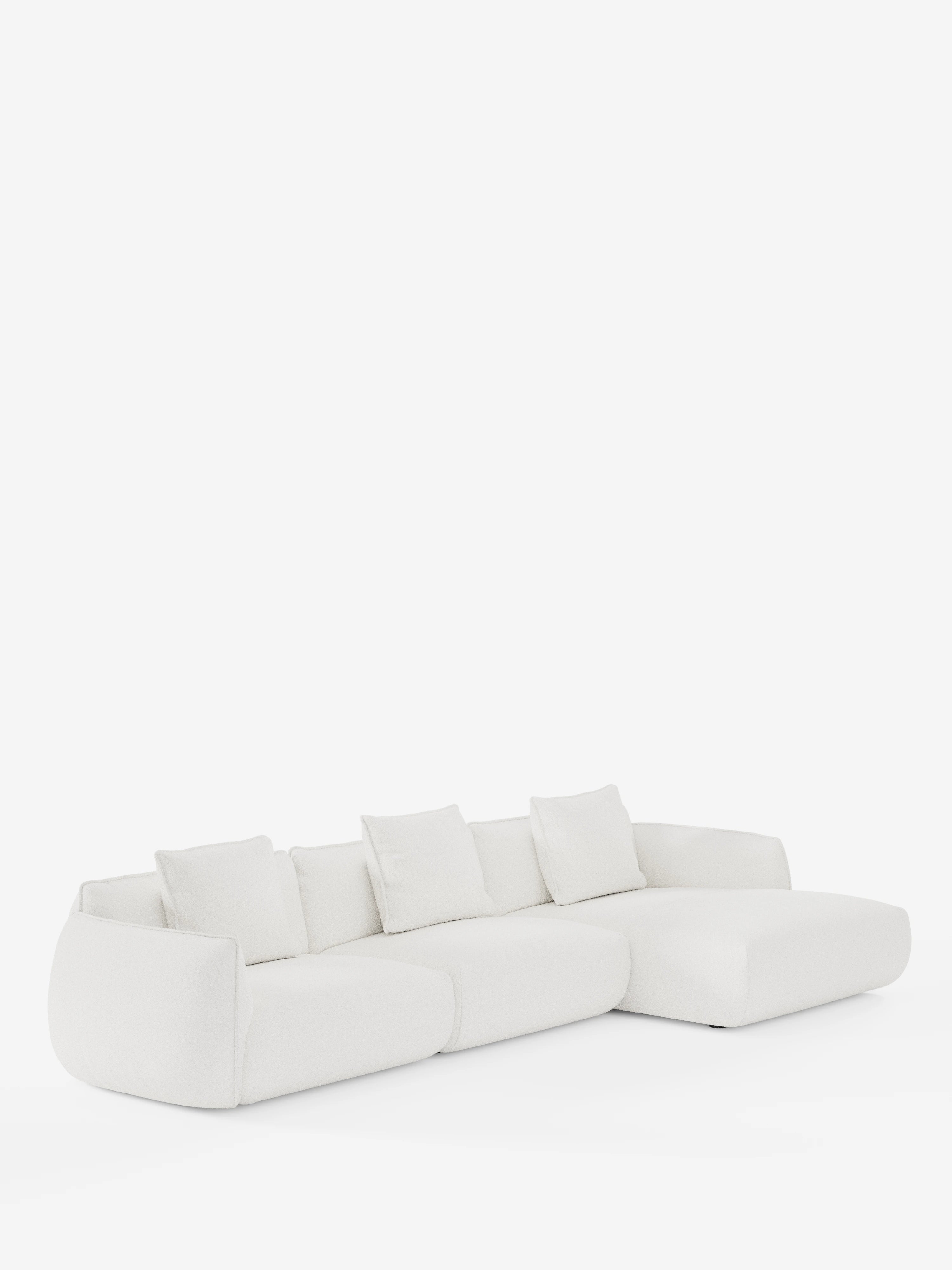 Un divano componibile contemporaneo bianco a forma di L: il divano angolare con penisola componibile Nimbus di Divani.Store, realizzato in morbido tessuto effetto cotone antimacchia T33, caratterizzato da morbidi bordi arrotondati e quattro cuscini schienali quadrati, in primo piano su uno sfondo bianco a tinta unita.