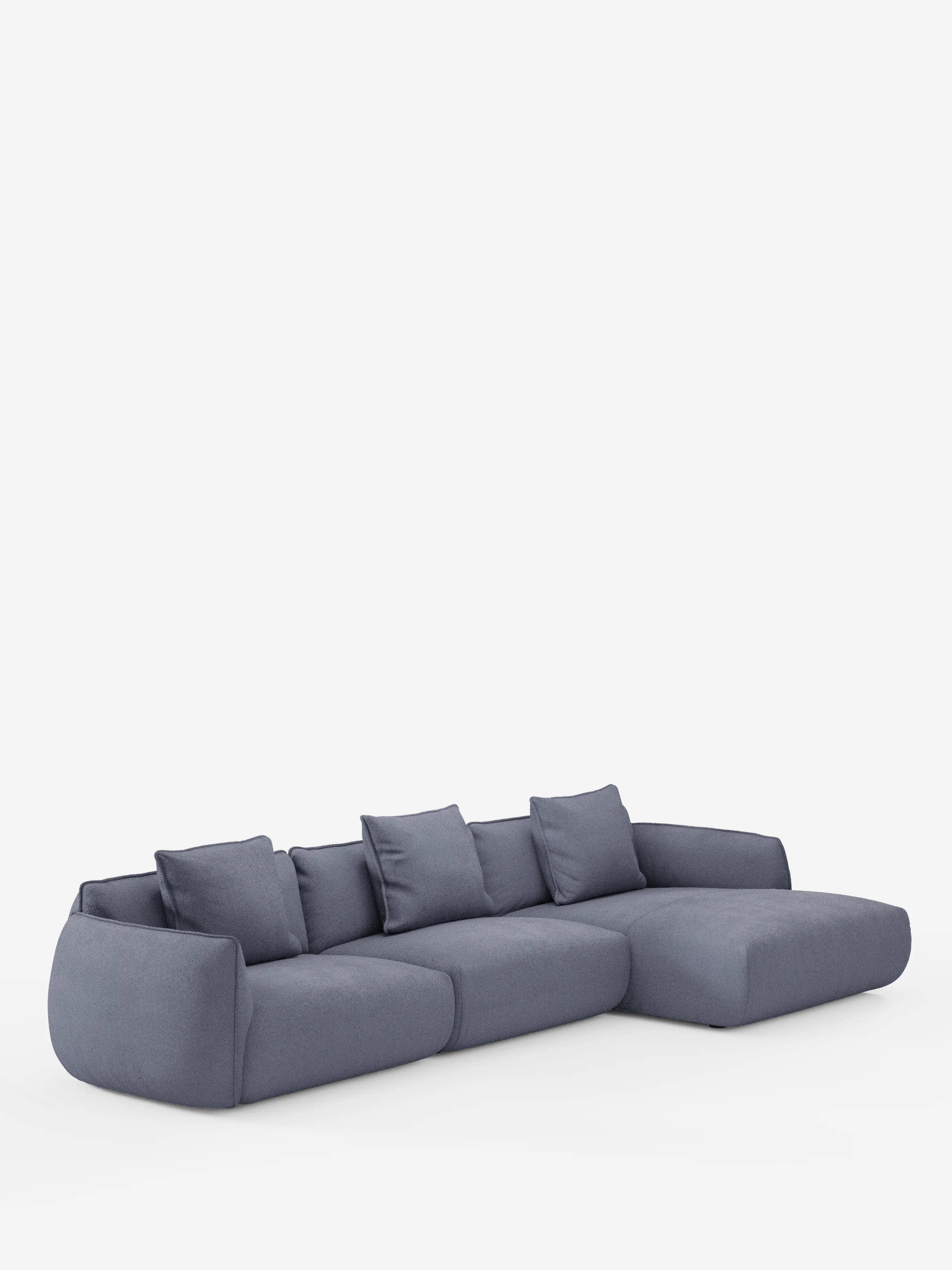 Un divano angolare con penisola componibile Nimbus dal design contemporaneo e dalle linee sobrie, realizzato da Divani.Store, rivestito in morbido tessuto T33 effetto cotone, resistente alle macchie, in una tonalità di blu tenue, dotato di quattro cuscini di seduta, quattro cuscini dello schienale e una spaziosa chaise longue sul lato destro, il tutto su uno sfondo bianco a tinta unita.