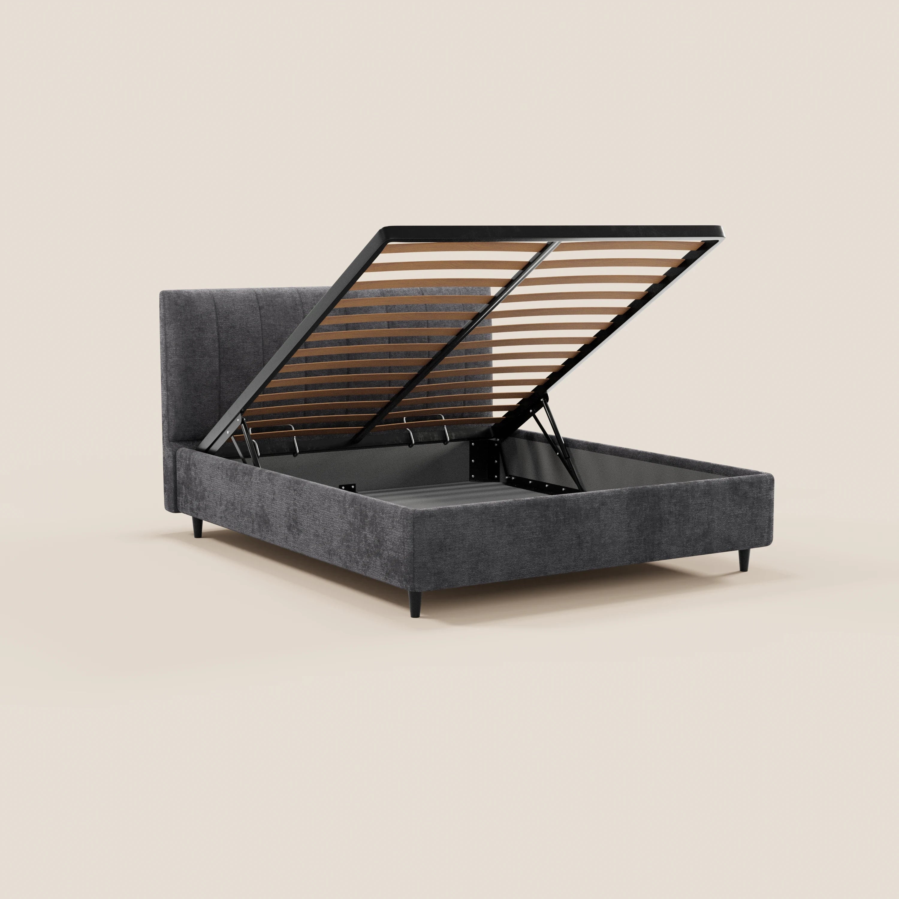 Il letto imbottito ONYX con contenitore di Letti.store, in tessuto Oeko-Tex® grigio scuro, è raffigurato su uno sfondo beige. La testiera verticale trapuntata e le gambe nere slanciate completano il design moderno, che offre un ampio spazio contenitore.