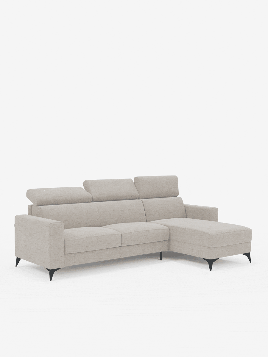Un divano letto angolare Pegaso color beige chiaro di Divani.Store, dotato di tre cuscini di seduta, poggiatesta regolabili, una chaise longue sul lato destro con penisola contenitore in tessuto jacquard antimacchia T22 e sottili gambe angolate nere, il tutto su uno sfondo bianco a tinta unita.