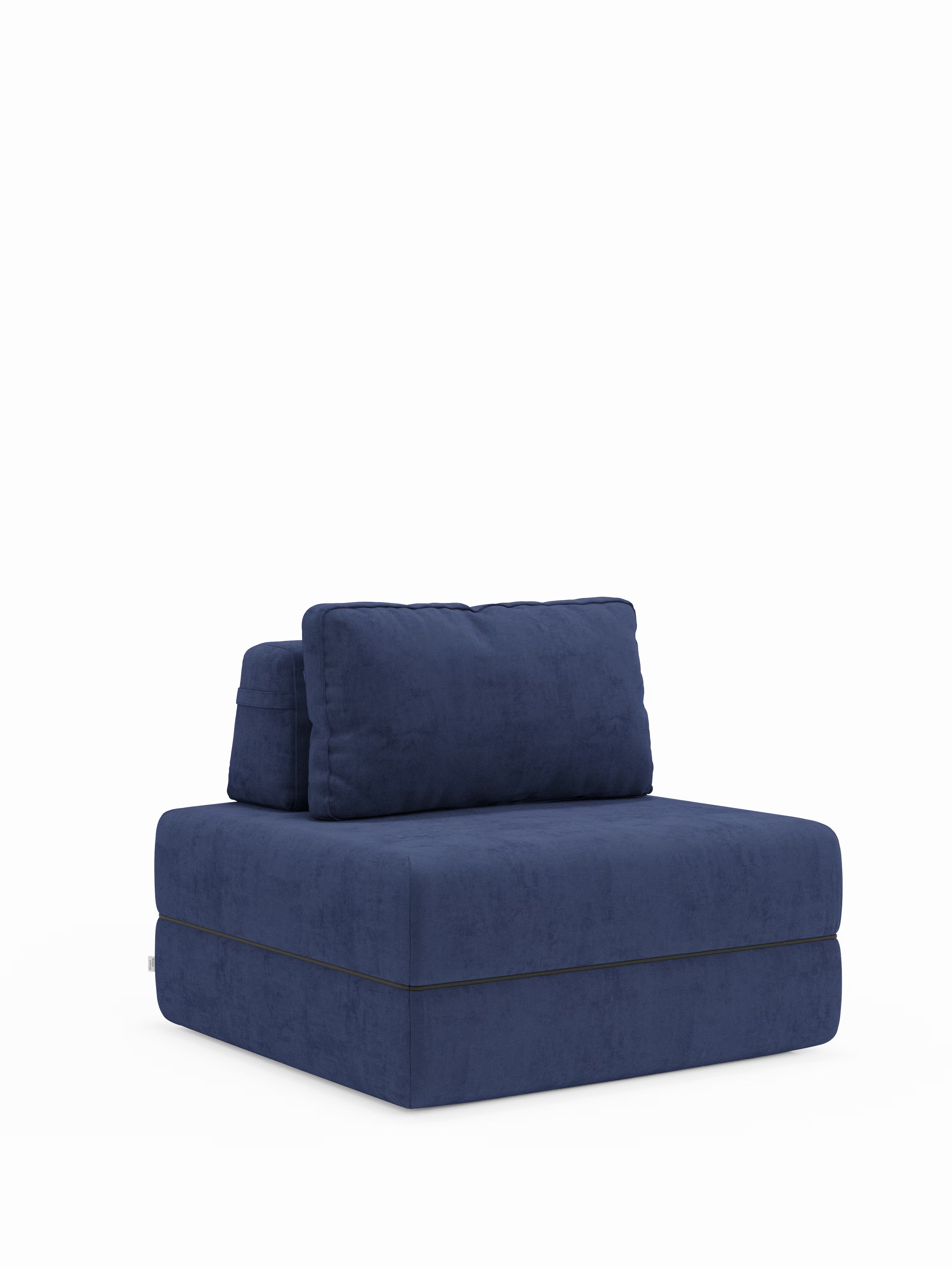 Una poltrona senza braccioli dal design contemporaneo, la Rift poltrona letto di Divani.Store, è rivestita in tessuto T31 blu scuro antimacchia e presenta una seduta imbottita con un materasso in memory foam alto 22 cm. È dotata di un cuscino schienale rettangolare rimovibile e poggia su una base bassa e squadrata che le conferisce un’estetica minimalista e moderna. Lo sfondo è bianco a tinta unita.