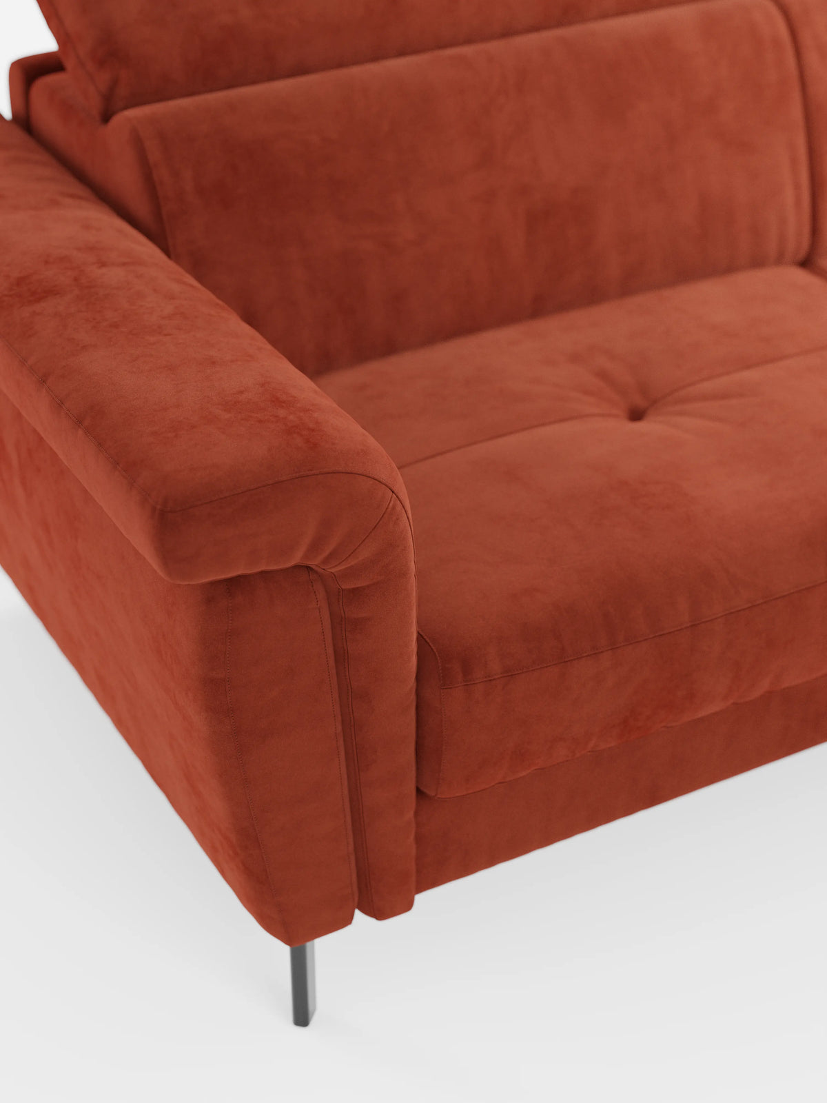 Primo piano del divano letto di design Capri di Divani.Store, rivestito in tessuto T30 color ruggine, smacchiabile, effetto velluto. L'immagine mette in risalto la slanciata gamba in metallo nero, i braccioli, lo schienale con poggiatesta regolabili e il cuscino di seduta con bottoni a vista su uno sfondo bianco: un'elegante vetrina della manifattura italiana.