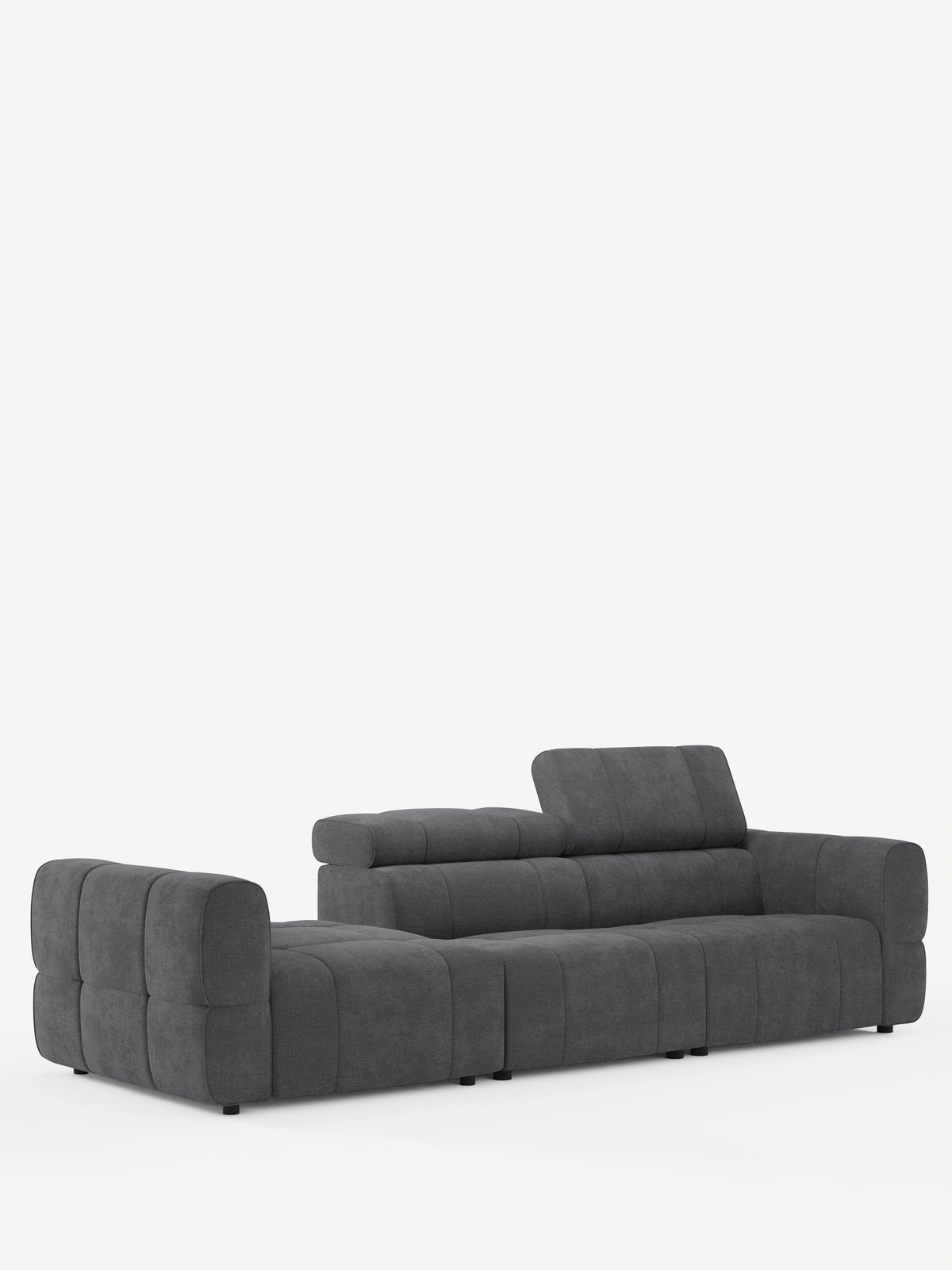 Un divano componibile Giotto Divano color grigio antracite con terminale aperto – opzione relax elettrico in tessuto smacchiabile T23 – è posizionato su uno sfondo bianco; presenta un design dal profilo basso con cuscini trapuntati e un poggiatesta verticale.
