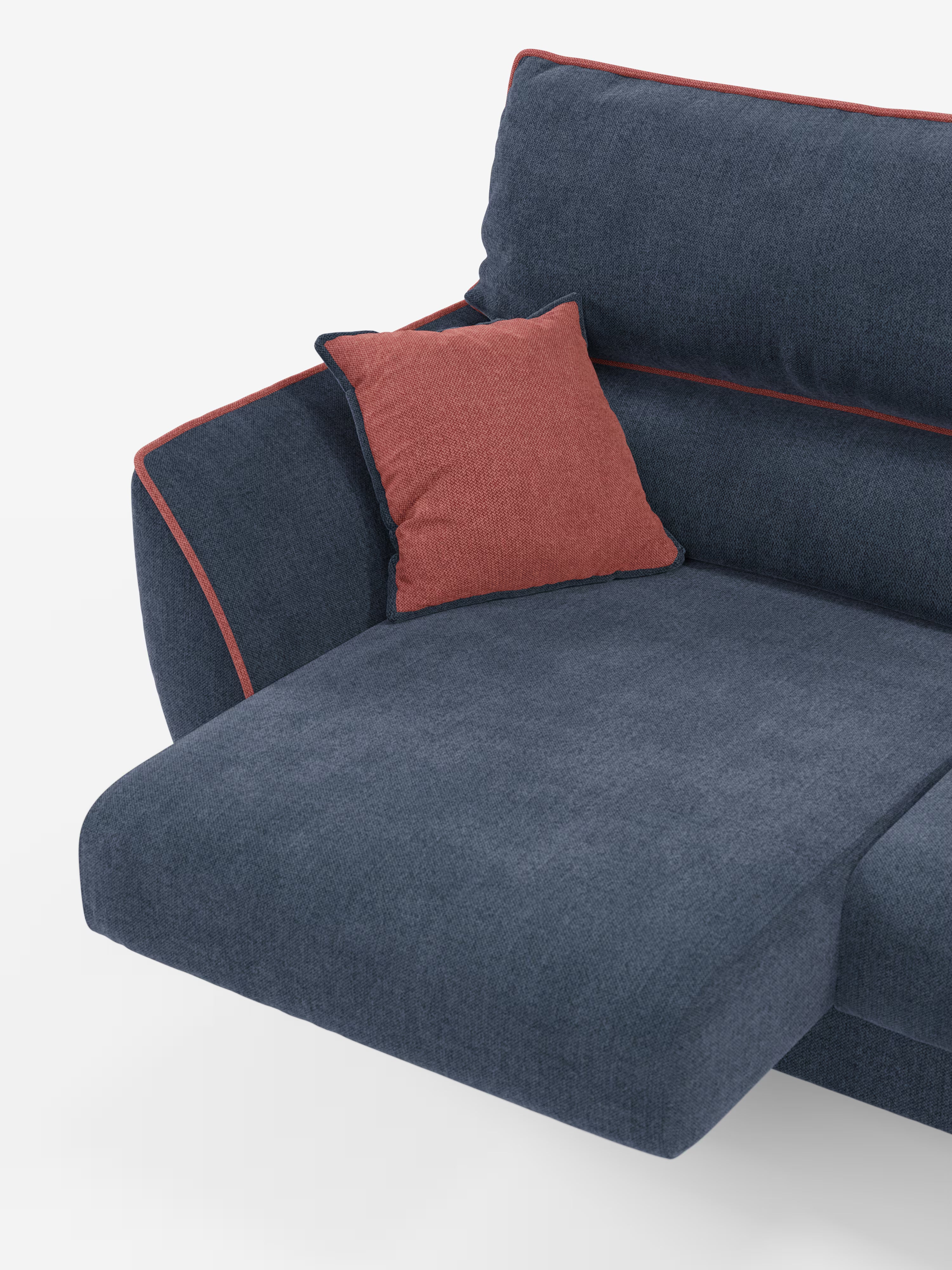 Un divano angolare Michelangelo bicolore in stile contemporaneo con penisola e sedute estensibili di Divani.Store, rivestito in tessuto antimacchia blu scuro (T23) con un accattivante bordino color corallo, e completato da un cuscino decorativo abbinato dello stesso colore. L’immagine mostra solo il lato sinistro del divano, mettendo in risalto il poggiatesta reclinabile, il bracciolo e l’ampia superficie di seduta su uno sfondo bianco pulito.