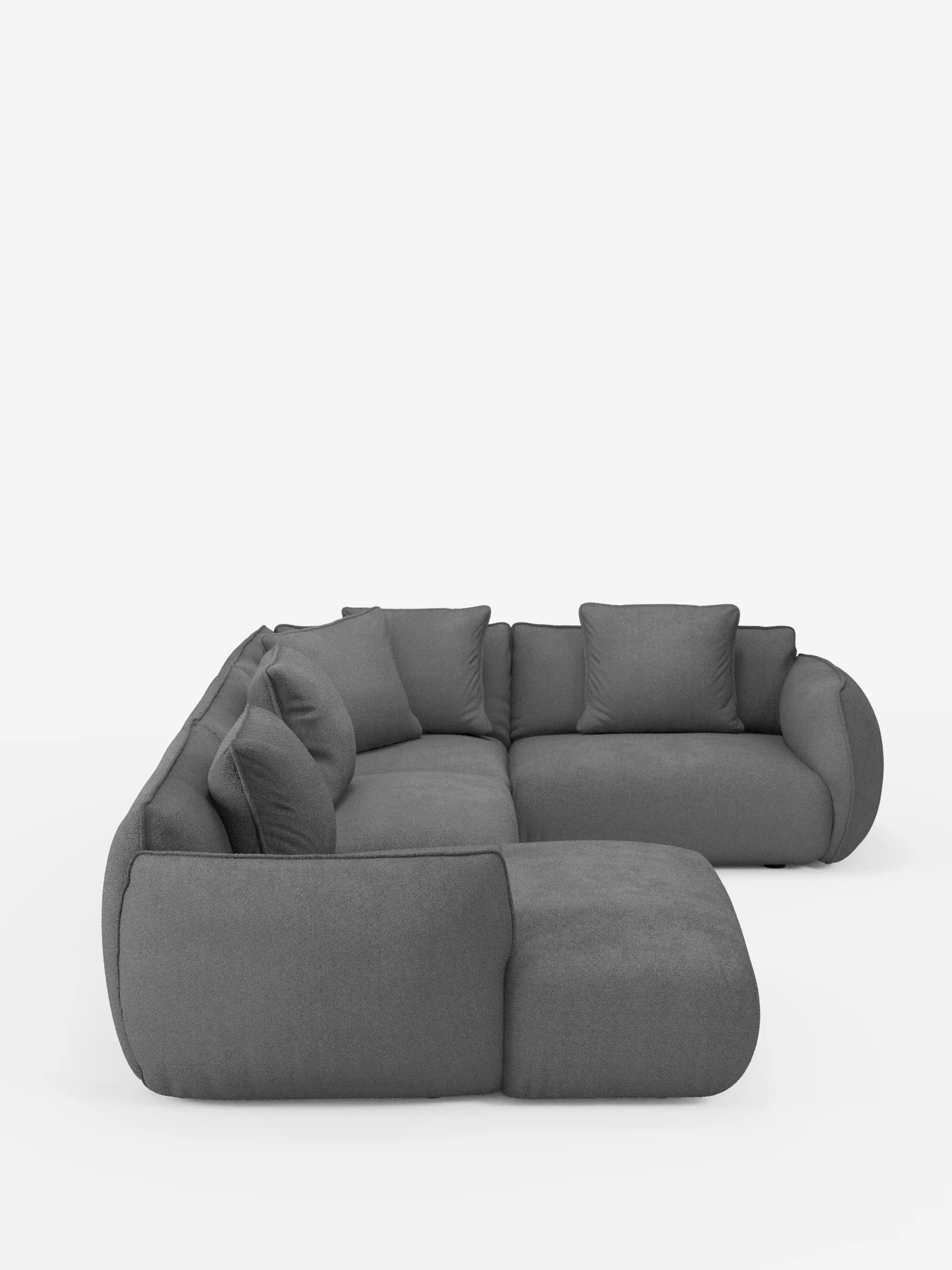 Un divano angolare panoramico componibile Nimbus in stile contemporaneo con penisola e angolo in tessuto antimacchia T33 di Divani.Store, rivestito in tessuto grigio scuro antimacchia, caratterizzato da morbidi cuscini, braccioli ricurvi e un design minimalista con sedute spesse e accoglienti e cinque cuscini schienali abbinati. Il divano componibile a forma di L è esposto su uno sfondo bianco.