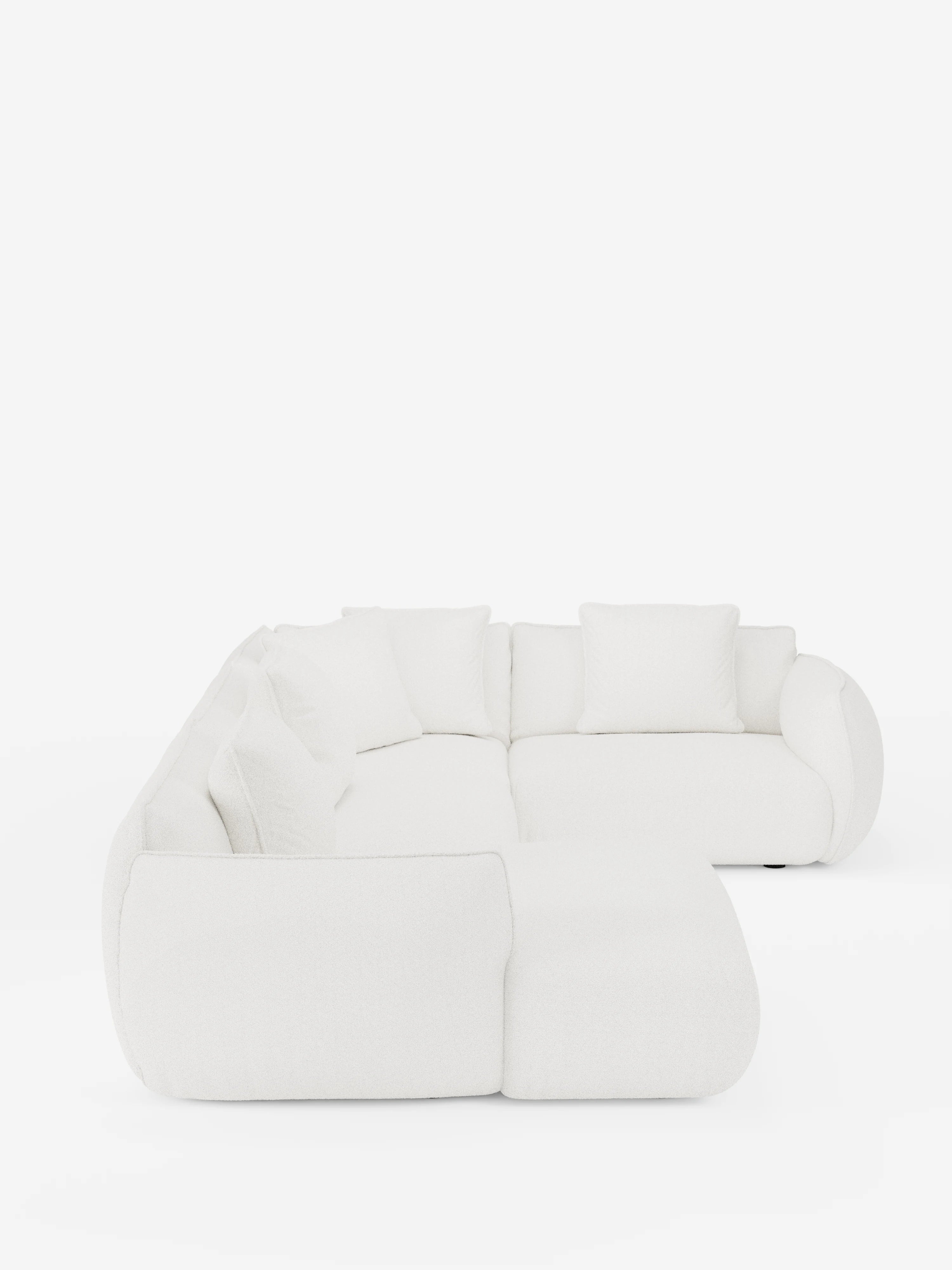 Un divano componibile moderno a forma di L di colore bianco — il divano angolare panoramico componibile con penisola e angolo in tessuto smacchiabile t33 della linea Nimbus di Divani.Store — è posizionato su uno sfondo bianco. Caratterizzato da bordi arrotondati, morbida tappezzeria antimacchia e cuscini coordinati, questo divano angolare modulare panoramico emana uno stile minimalista e accogliente. Non sono visibili altri oggetti.