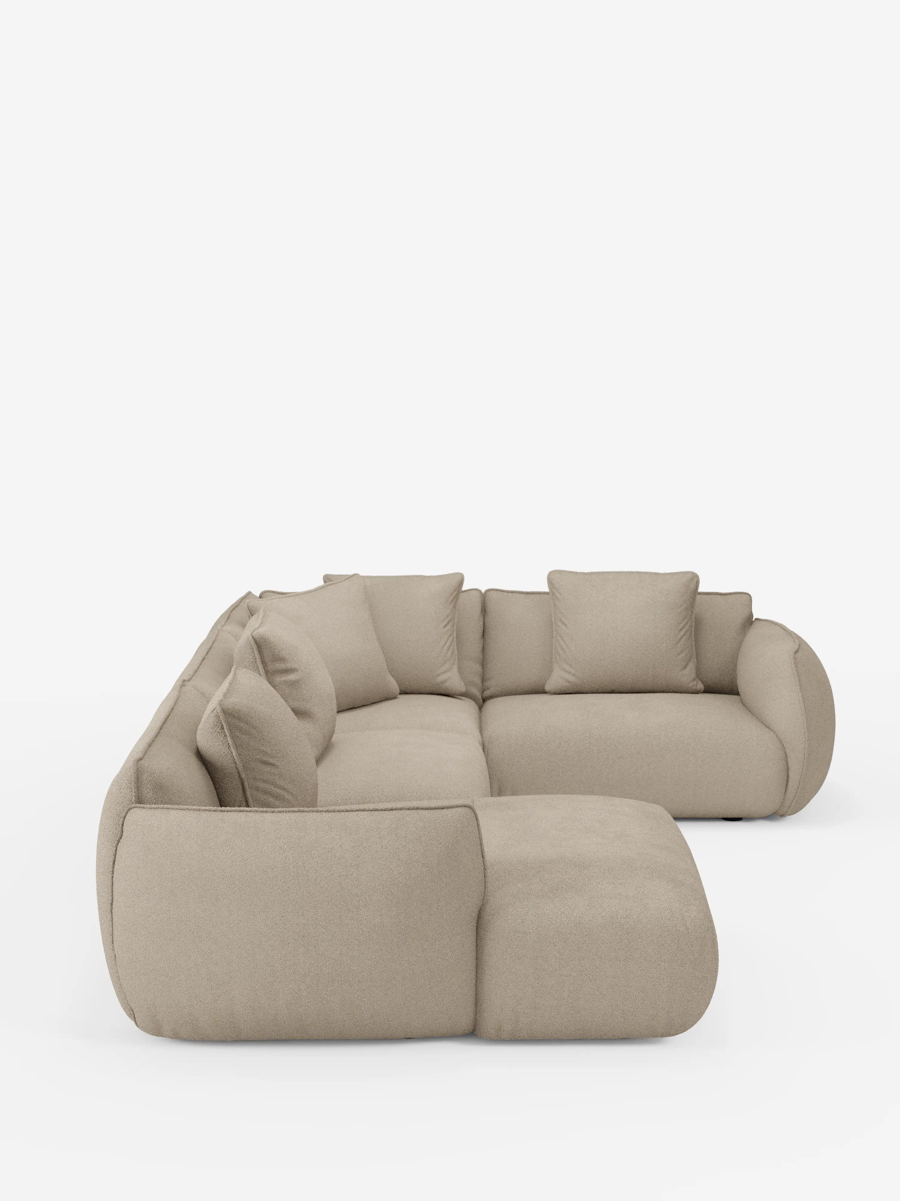 Un divano angolare panoramico componibile Nimbus in stile contemporaneo con penisola e angolo in tessuto smacchiabile T33 di Divani.Store, caratterizzato da un design a forma di L con bordi morbidi e arrotondati e cinque cuscini dello schienale abbinati in beige, è esposto su uno sfondo bianco a tinta unita. Questo divano componibile minimalista e accogliente, Made in Italy, offre una soluzione versatile perfetta per gli spazi abitativi moderni.