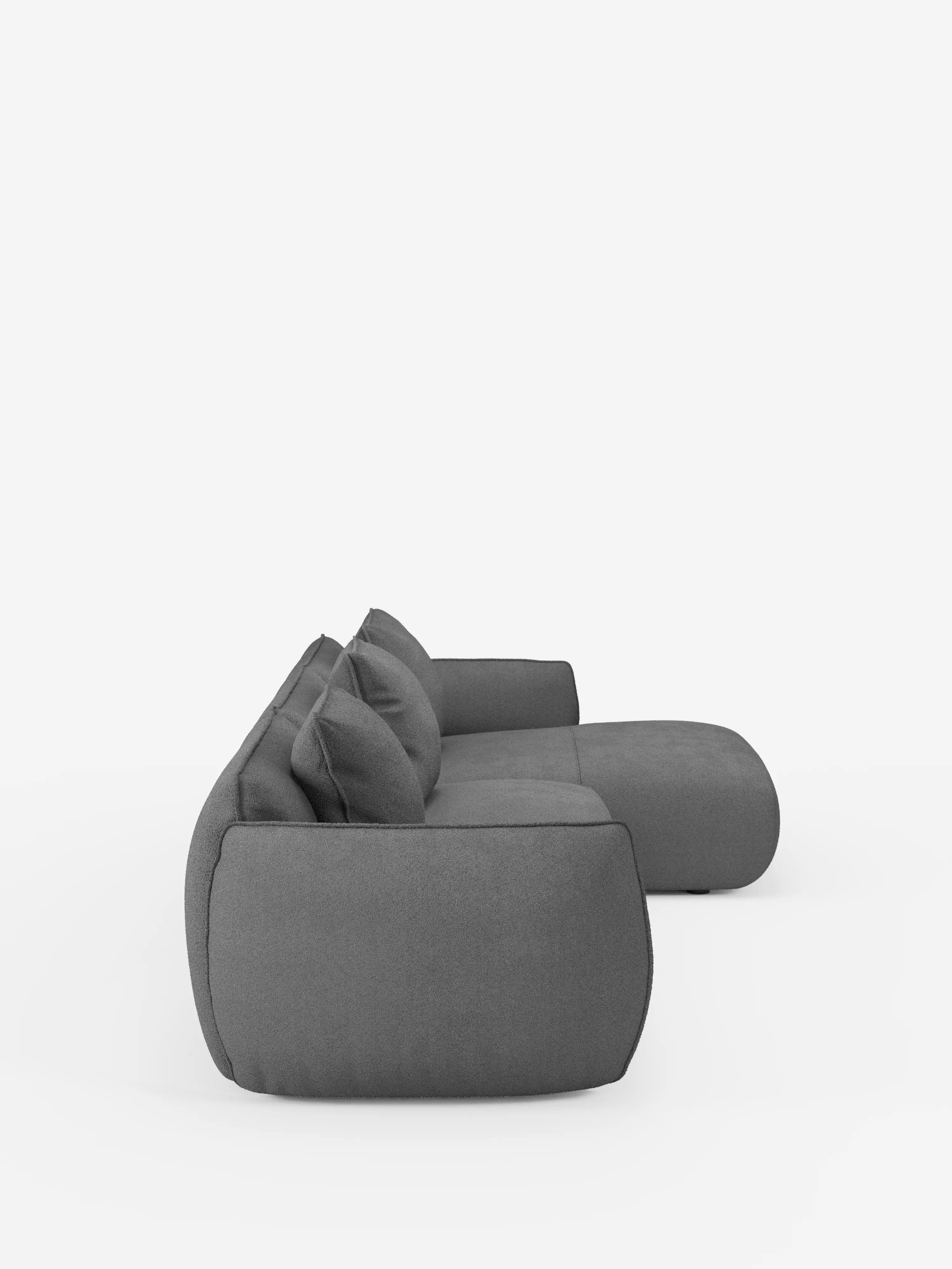 Una vista laterale mostra il divano angolare con penisola componibile Nimbus di Divani.Store, un divano moderno dal profilo basso, di colore grigio, realizzato in morbido tessuto T33 effetto cotone, resistente alle macchie. Caratterizzato da due cuscini dello schienale e da un bracciolo imbottito e morbido con bordi arrotondati e cuscini di seduta spessi, questo complemento d’arredo contemporaneo è messo in risalto da uno sfondo bianco a tinta unita.