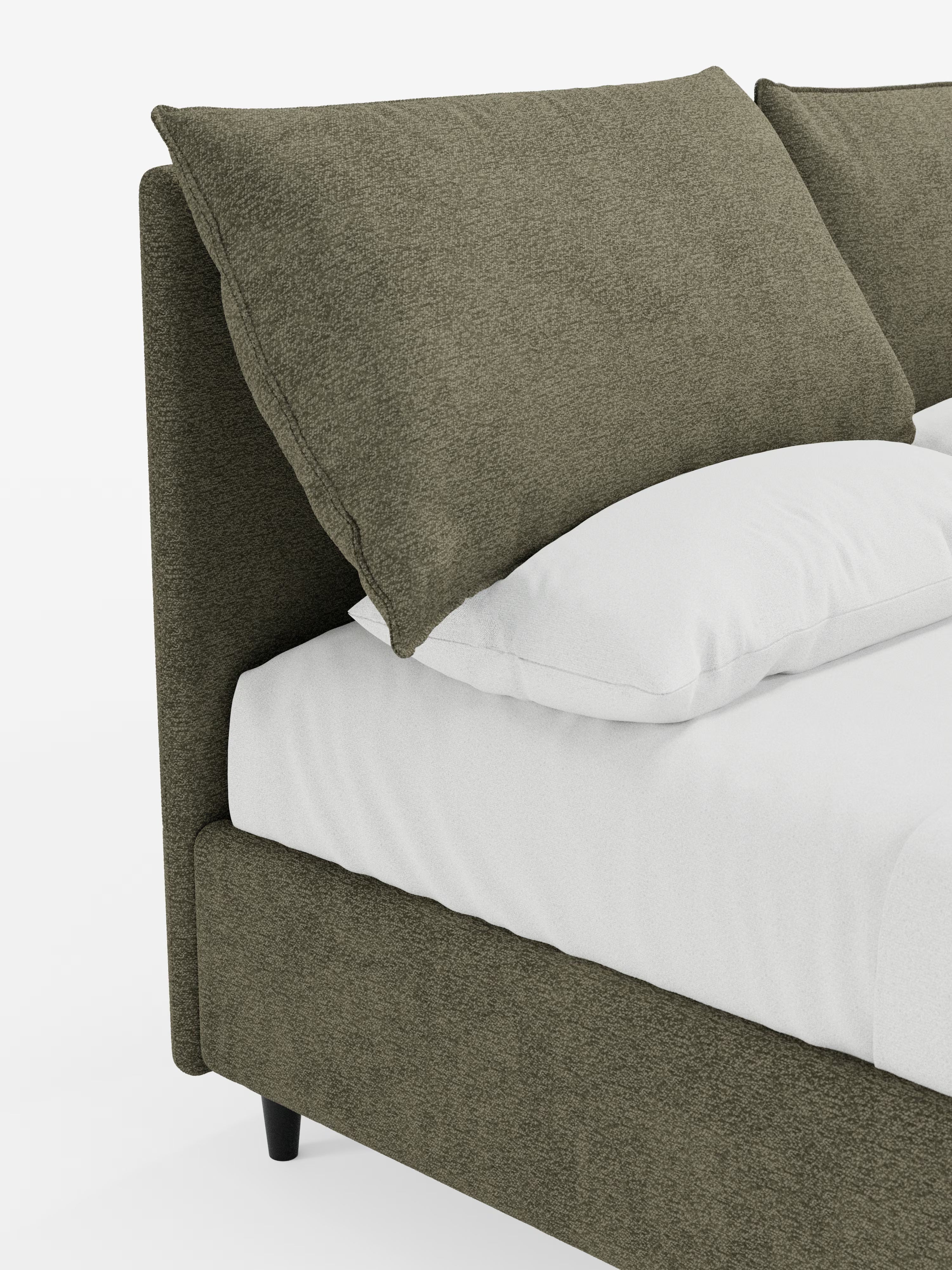 Un primo piano del letto imbottito ZAYRON con contenitore e morbidi cuscini regolabili di Letti.store mette in risalto la sua struttura rivestita in verde oliva, certificata Oeko-Tex®, e il cuscino abbinato dalle dimensioni generose. Con il suo design moderno, il lenzuolo bianco e il cuscino, disposti con cura, si trovano sotto il soffice cuscino regolabile. Lo sfondo bianco a tinta unita esalta la texture raffinata e l’estetica pulita del letto.