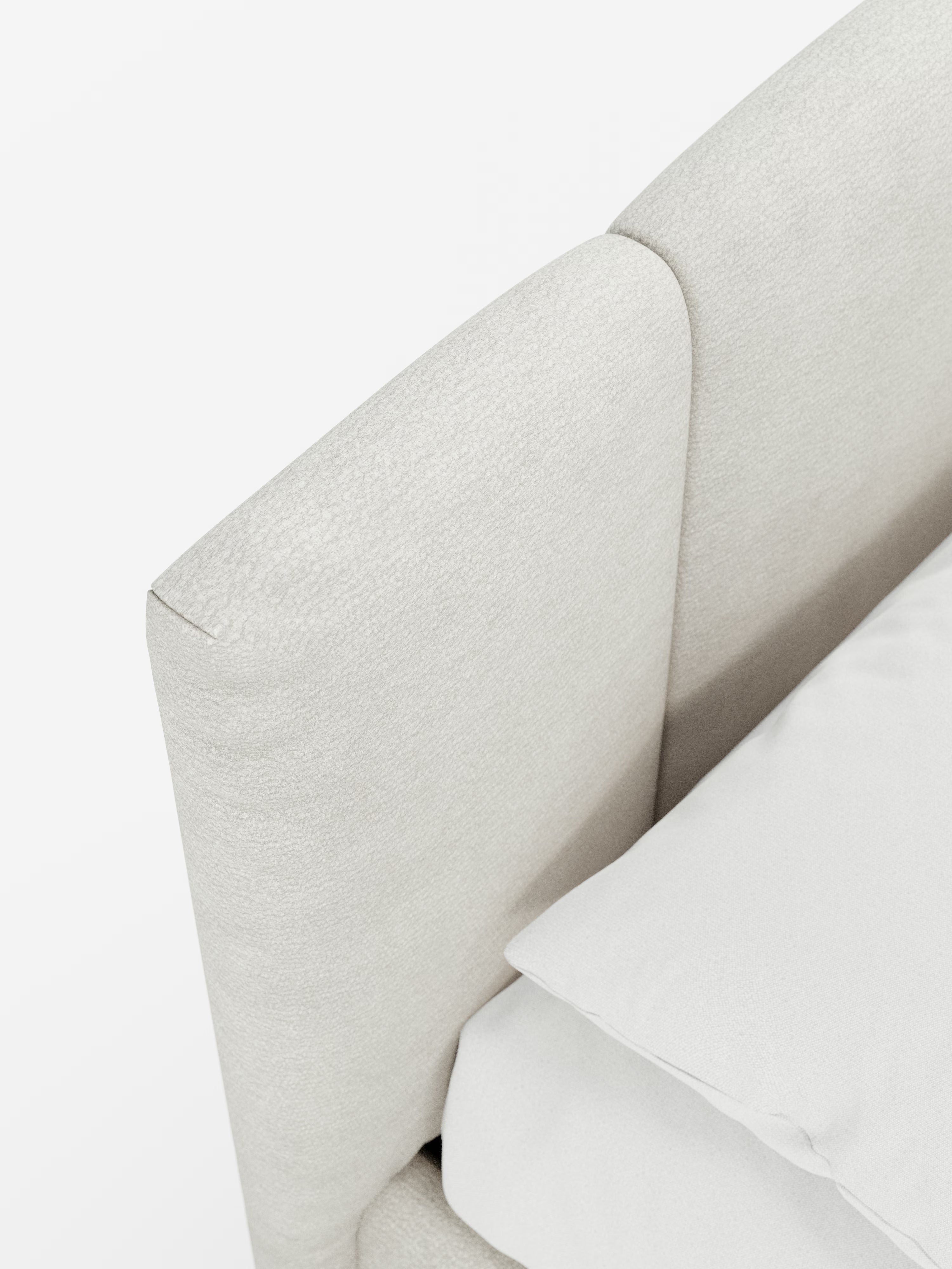 Primo piano di un letto imbottito ARKAM con contenitore e testiera a lavorazione verticale di Letti.store, caratterizzato da una testiera imbottita in tessuto beige chiaro con trama in rilievo, certificata Oeko-Tex®, in stile shabby chic e da un letto ben rifatto con biancheria da letto bianca, ripreso dall’alto su uno sfondo bianco.