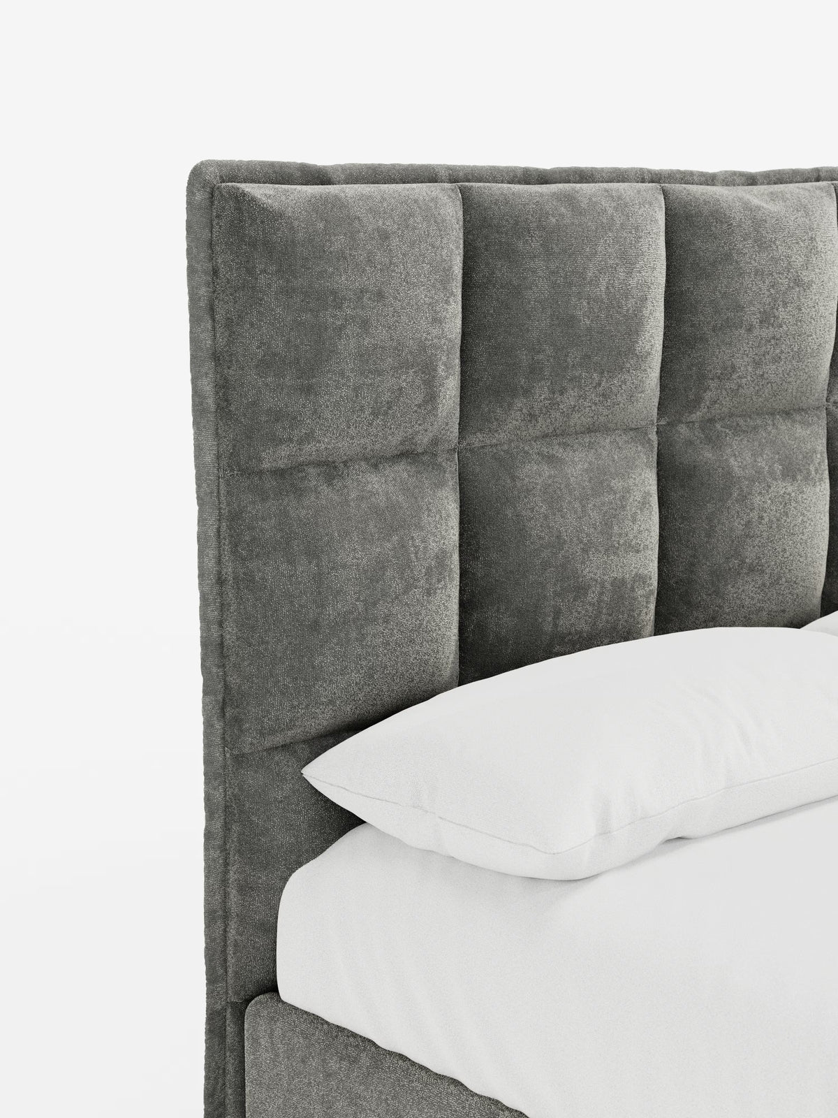 Ecco una versione rielaborata della frase utilizzando i dati del tuo prodotto: Un primo piano del letto imbottito AURO con contenitore e testiera capitonné alta in ciniglia Oeko-Tex® di Letti.store mette in risalto la sua testiera grigia capitonné, con sezioni quadrate imbottite e la morbida trama in ciniglia. Il cuscino e il materasso bianchi risaltano sullo sfondo bianco a tinta unita, sottolineando il design moderno e minimalista del letto.