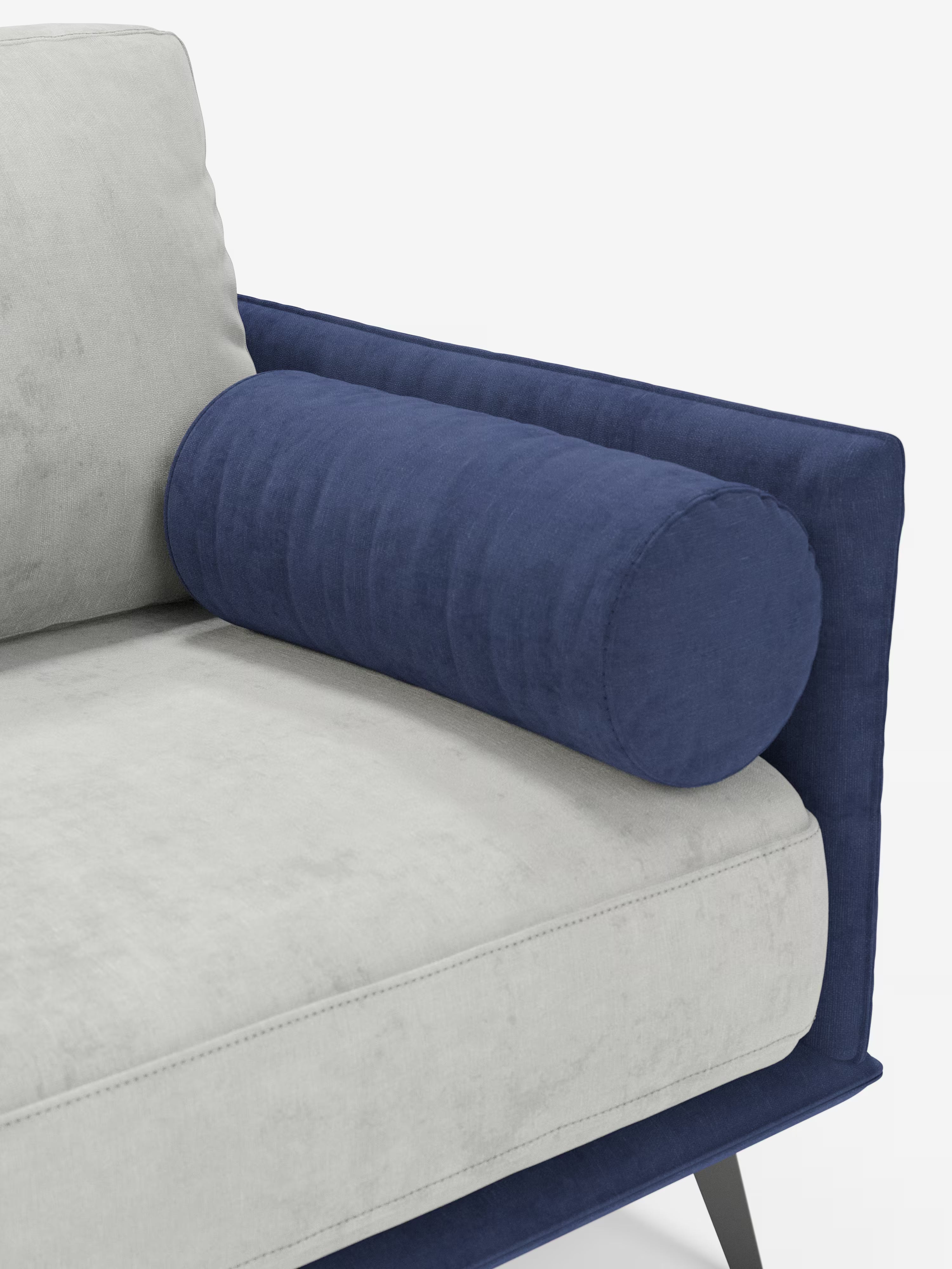 Un primo piano del divano Basalto Divano lineare a 2 o 3 posti bicolore di Divani.Store mette in risalto un divano moderno dal design monoposto, rivestito in tessuto T31 grigio chiaro antimacchia, impreziosito da un cuscino cilindrico blu scuro appoggiato al bracciolo imbottito dello stesso colore. Questo divano contemporaneo presenta linee pulite e gambe angolari in metallo nero, fondendo perfettamente stile e comfort.