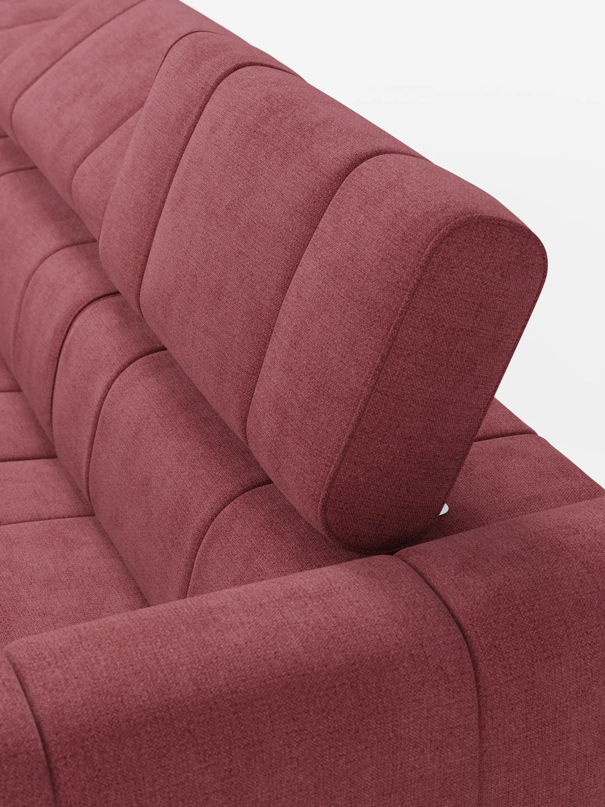 Un primo piano del divano modulare Giotto a 4 posti in rosa polveroso, con poggiatesta reclinabili e funzione relax elettrica opzionale, rivestito in tessuto smacchiabile T23, caratterizzato da un design moderno, una trama intrecciata a vista e cuciture verticali a canaletti sullo schienale.