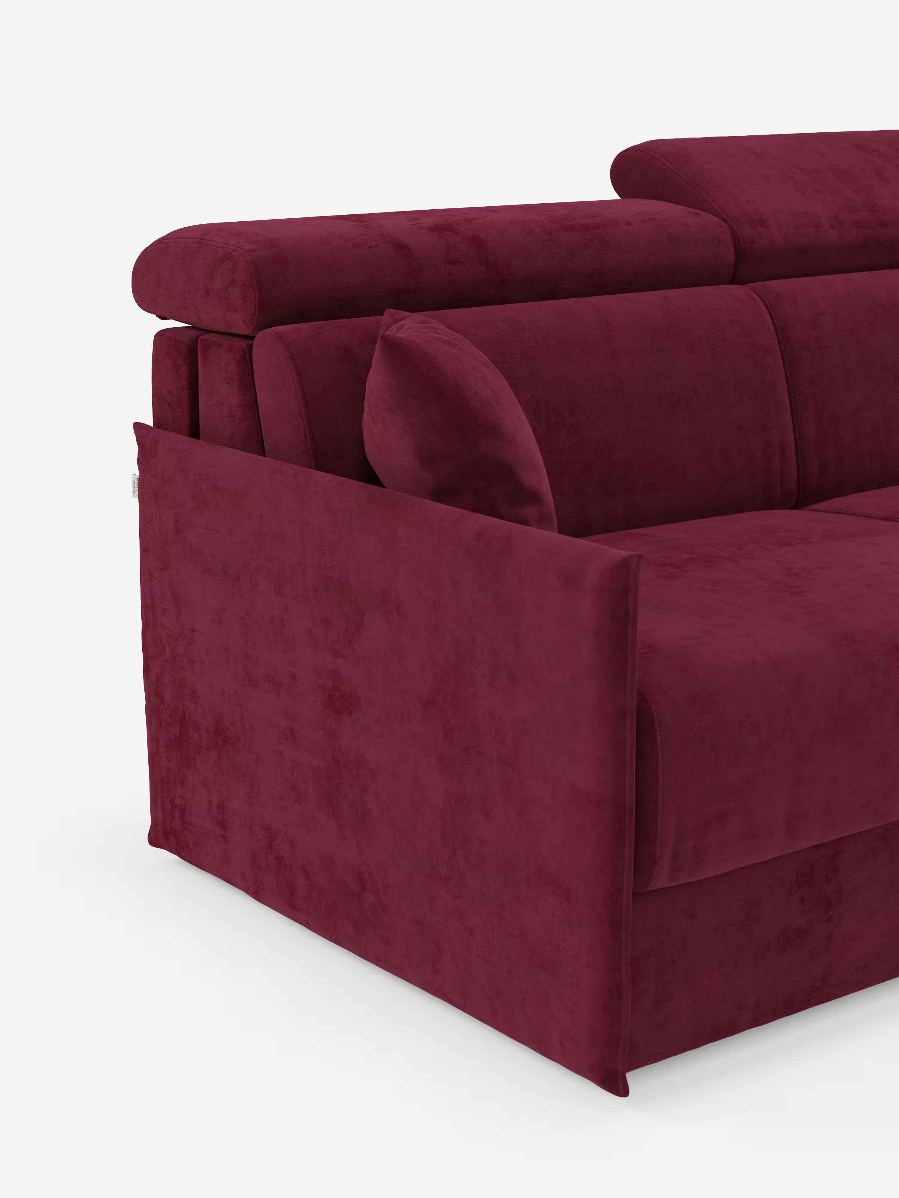 Un primo piano del divano letto Miryam con poggiatesta reclinabili e comfort maxi di Divani.Store, un moderno divano componibile rivestito in morbido tessuto smacchiabile T31 color bordeaux intenso. Caratterizzato da uno stile minimal contemporaneo e da un design compatto, l’immagine mette in risalto il bracciolo sinistro, parte dello schienale e un cuscino decorativo sulla seduta su uno sfondo bianco.