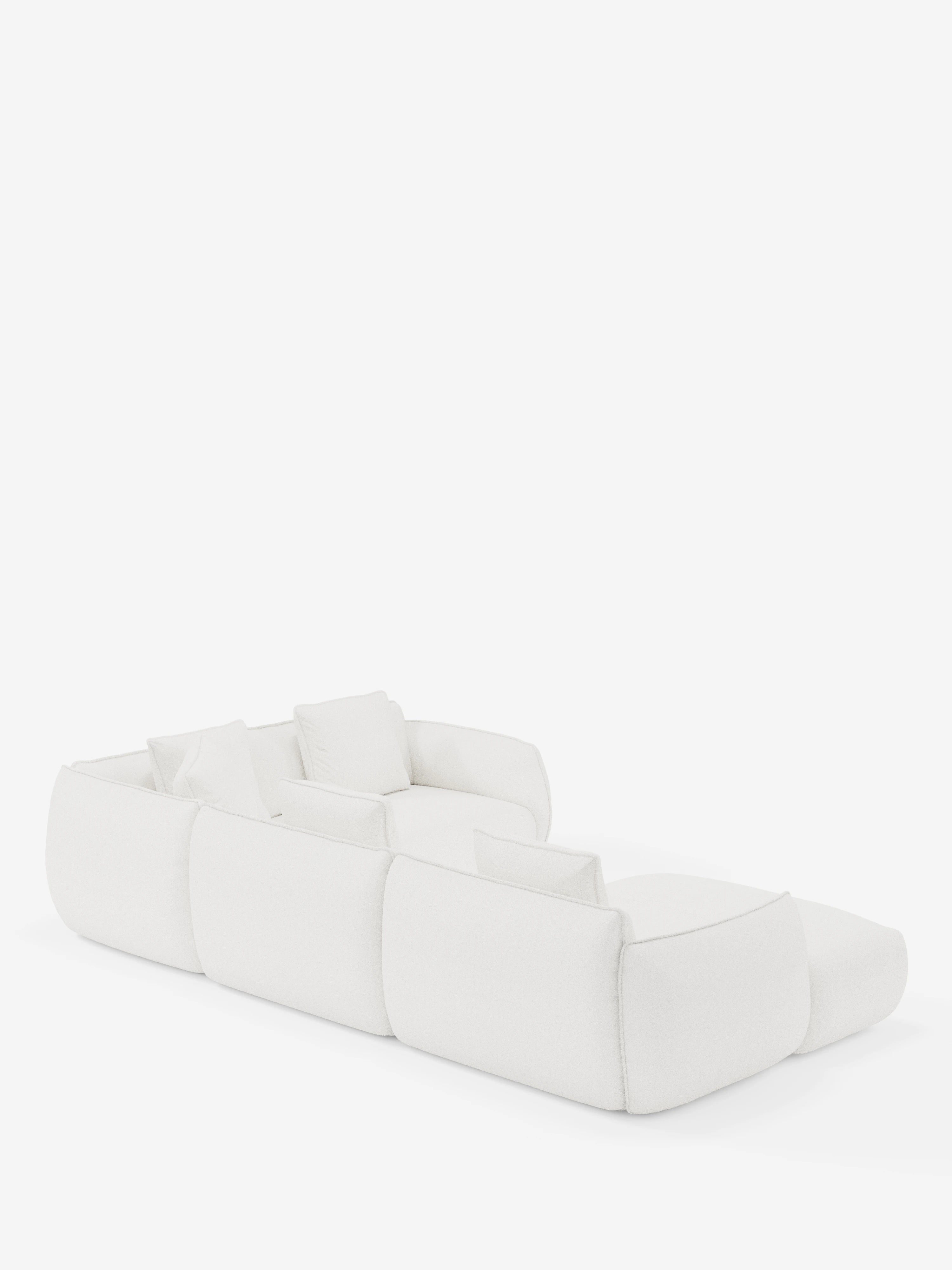 Un divano componibile bianco dal design contemporaneo — il divano angolare panoramico componibile Nimbus con penisola e angolo in tessuto smacchiabile T33 di Divani.Store — presenta tre posti con morbidi cuscini quadrati ed è posto su uno sfondo bianco a tinta unita. Realizzato in Italia, il divano presenta bordi morbidi e arrotondati e un design minimalista, che esalta sia il comfort che lo stile moderno.