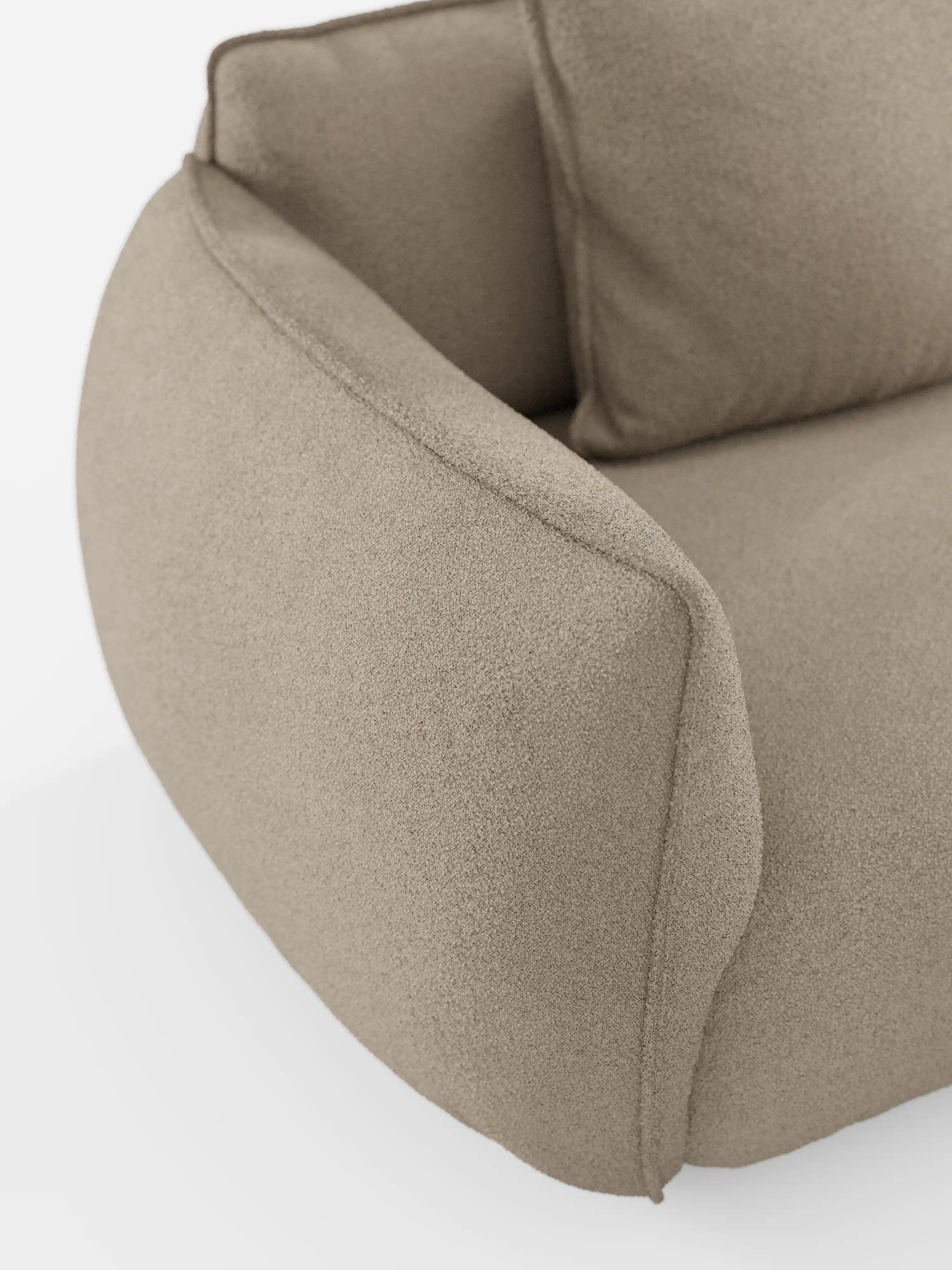 Primo piano del divano angolare con penisola componibile Nimbus di Divani.Store in beige, rivestito con il morbido tessuto T33 effetto cotone, resistente alle macchie. L’immagine mette in risalto il bracciolo dalle linee elegantemente sinuose, una parte del cuscino di seduta e lo schienale su uno sfondo bianco, evidenziando il morbido rivestimento e il design contemporaneo del divano, che garantiscono un comfort eccezionale.