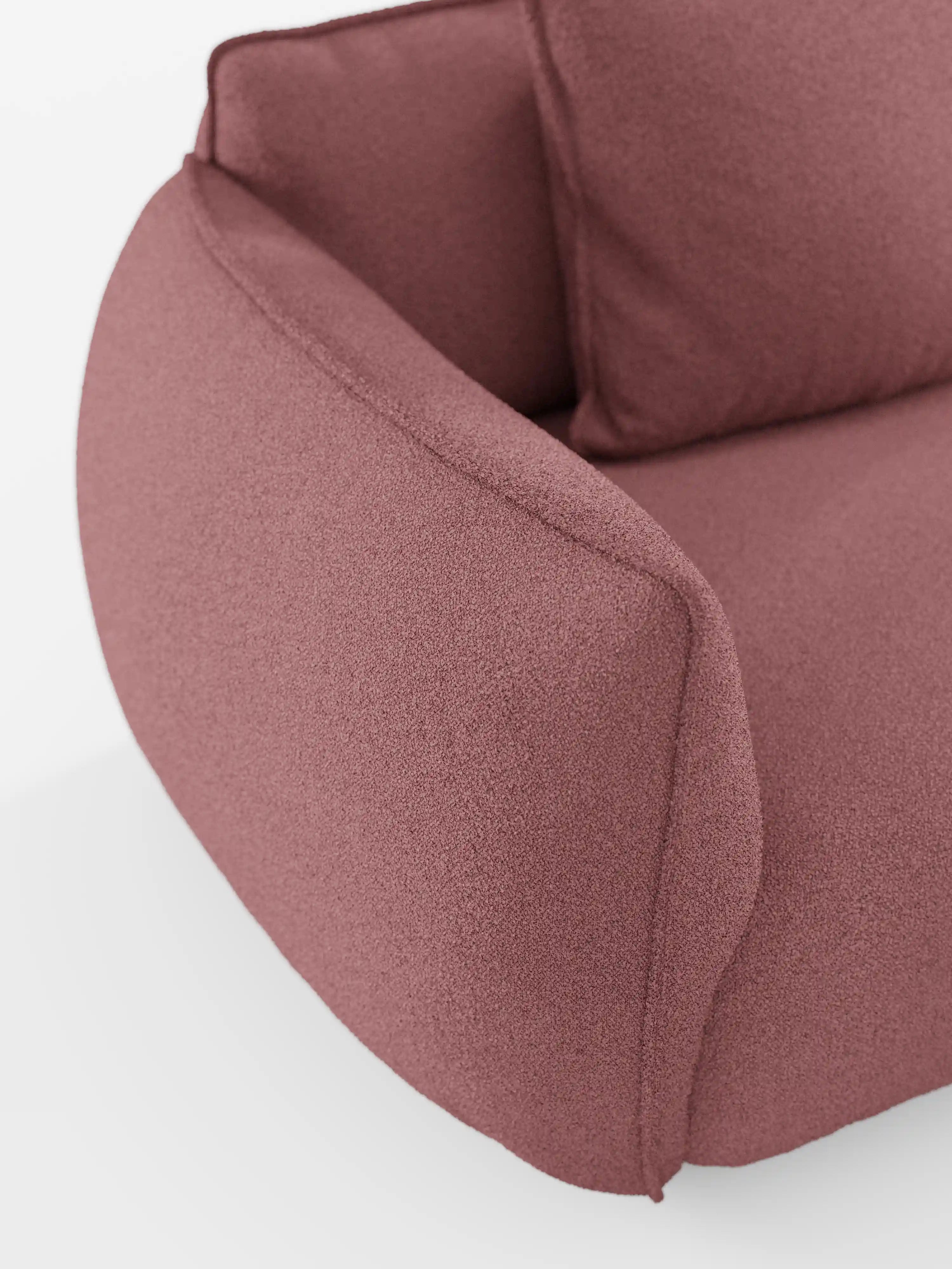 Primo piano del divano angolare con penisola componibile “Nimbus” di Divani.Store, caratterizzato da morbidi braccioli arrotondati e da uno schienale rivestito in morbido tessuto T33 effetto cotone, resistente alle macchie, color rosa polveroso. Su uno sfondo bianco, le curve delicate e le linee accoglienti evocano il comfort e lo stile moderno di questo divano angolare componibile.