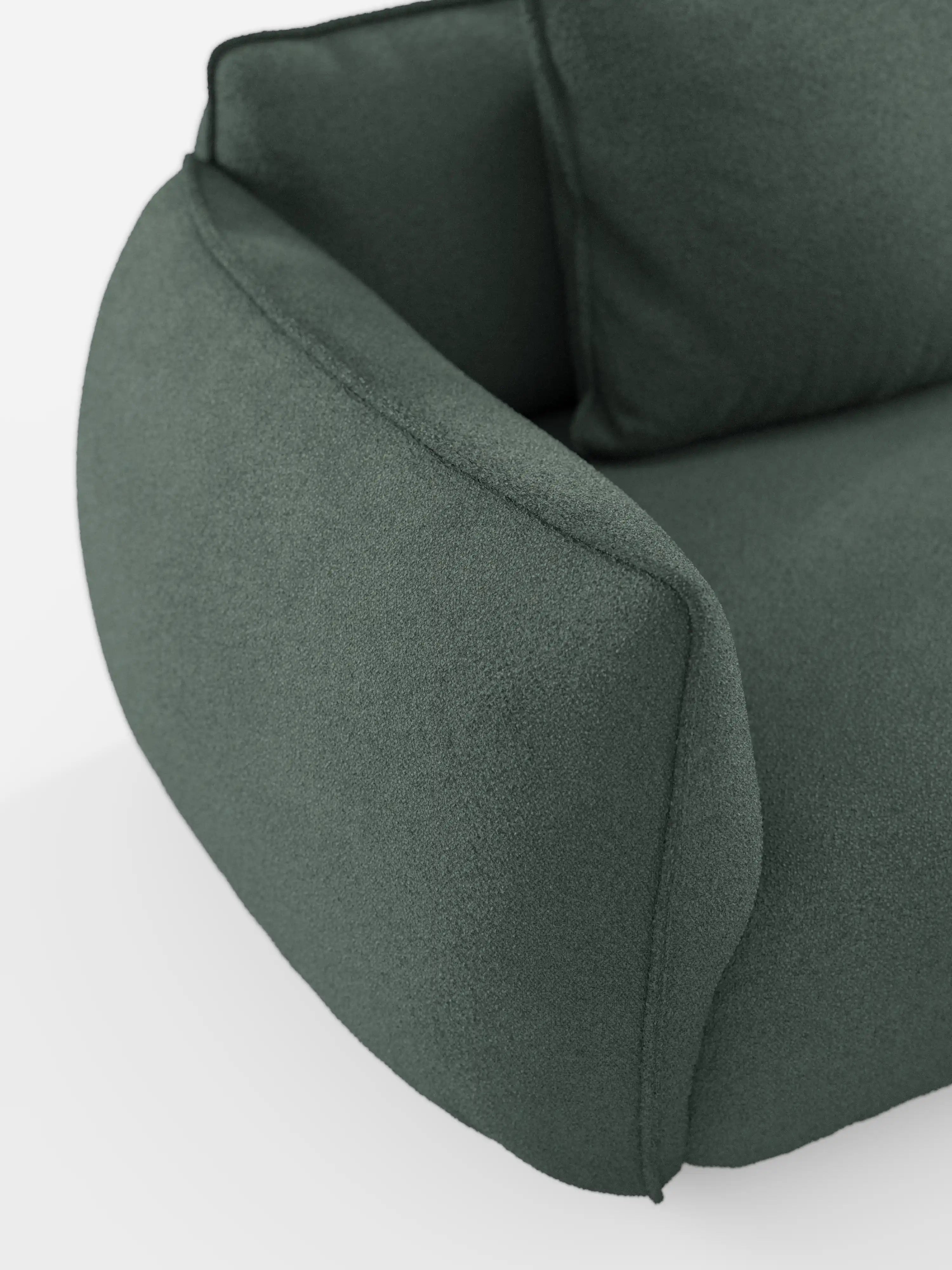 Primo piano del bracciolo e della seduta del divano angolare con penisola componibile Nimbus di Divani.Store, rivestito in tessuto T33 effetto cotone verde scuro, resistente alle macchie. Questo divano moderno presenta un design morbido e imbottito, con bordi arrotondati e uno stile contemporaneo minimalista, valorizzato dai dettagli delle cuciture a vista. In primo piano su uno sfondo bianco a tinta unita.