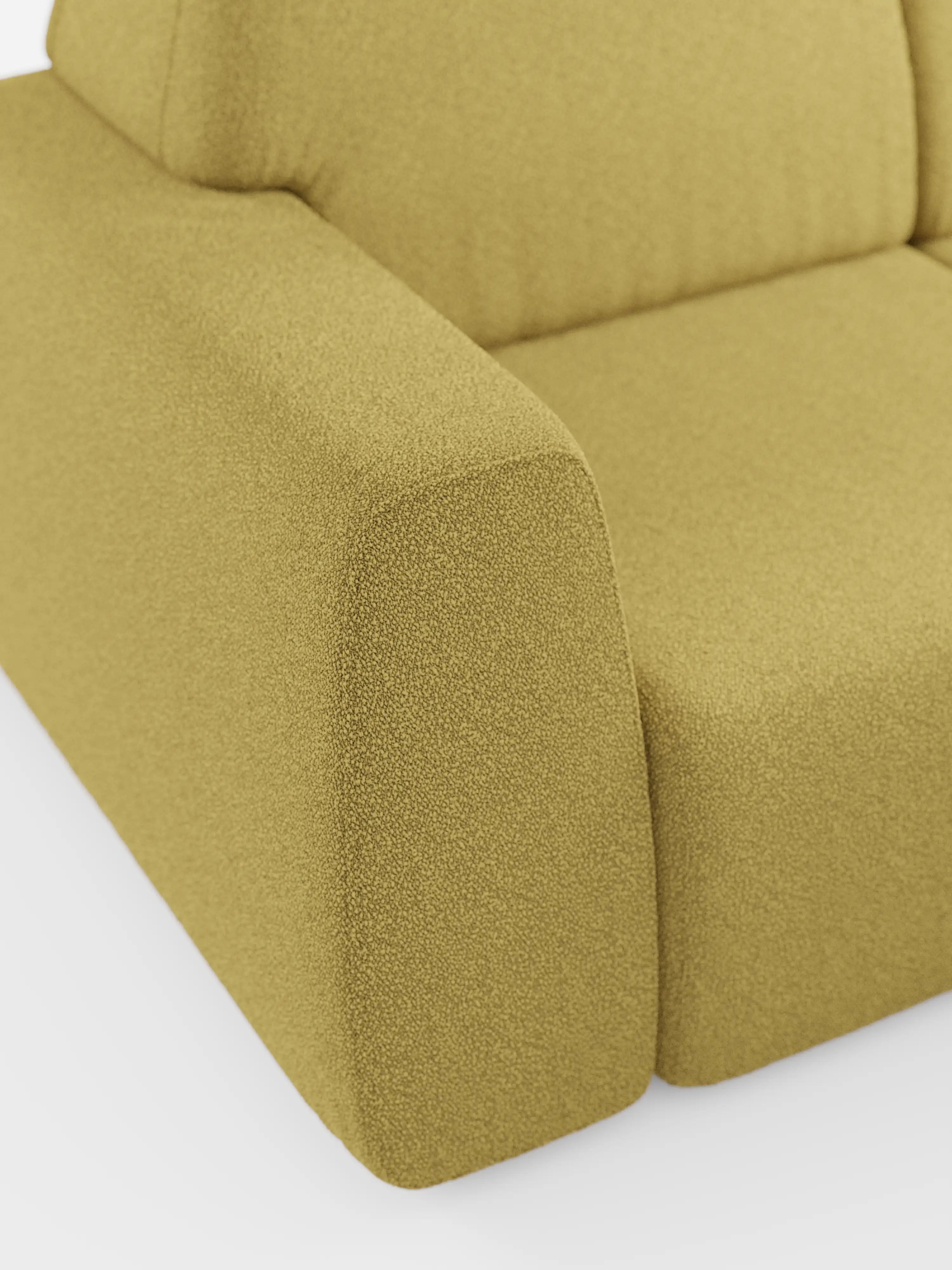 Primo piano del divano angolare Orbit con penisola reversibile e tutte le sedute allungabili, rivestito in tessuto smacchiabile effetto cotone T33 di Divani.Store. L'immagine mette in risalto gli ampi braccioli, la seduta e lo schienale, rivestiti in tessuto testurizzato color verde oliva chiaro. Questo divano componibile presenta un design minimalista e geometrico con bordi arrotondati ed è raffigurato su uno sfondo bianco.