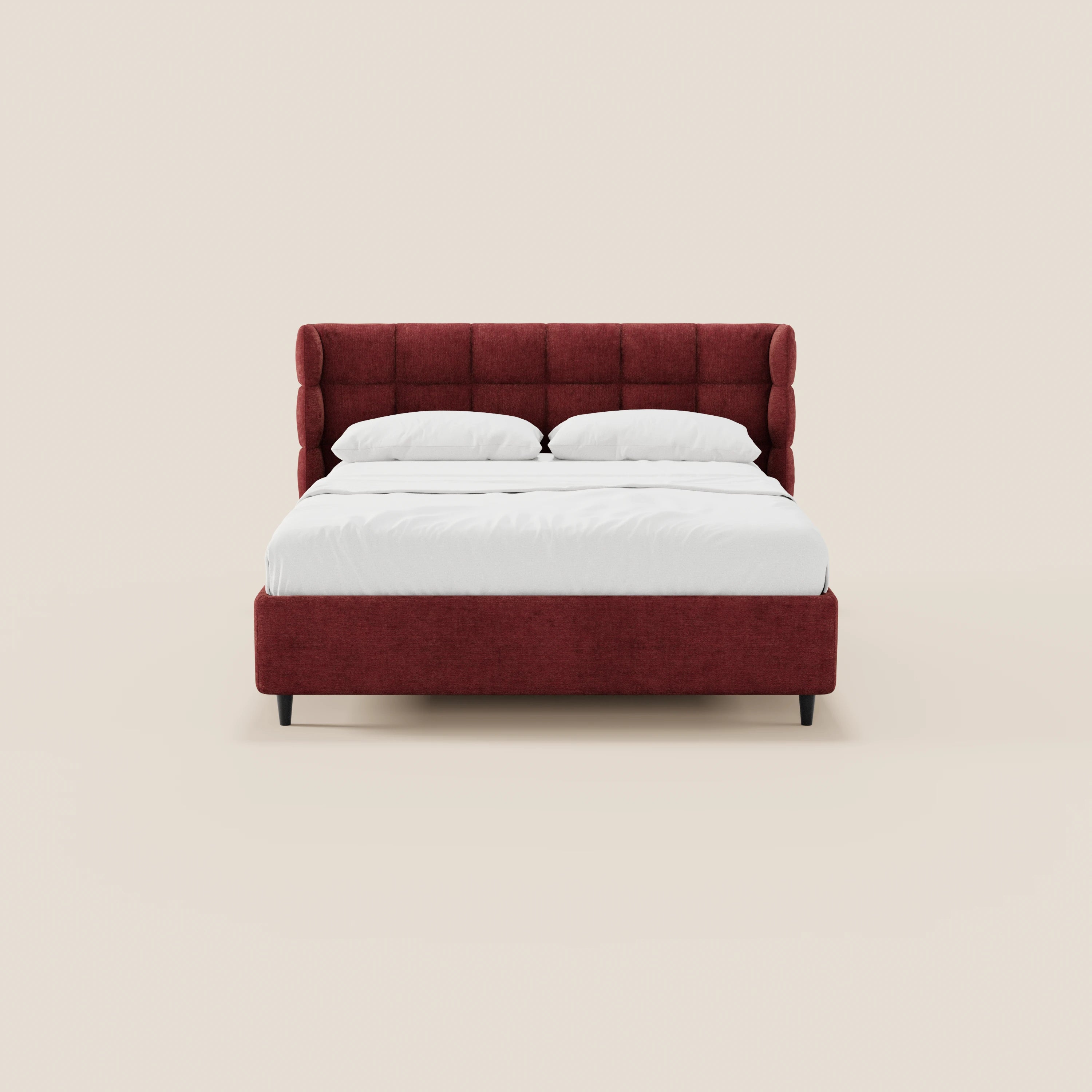 Il letto imbottito RAGNAR di Letti.store presenta una testiera avvolgente capitonné di colore rosso intenso, un elegante tessuto certificato Oeko-Tex®, biancheria da letto bianca con due cuscini e gambe nere. Design minimalista e simmetrico su uno sfondo beige chiaro.