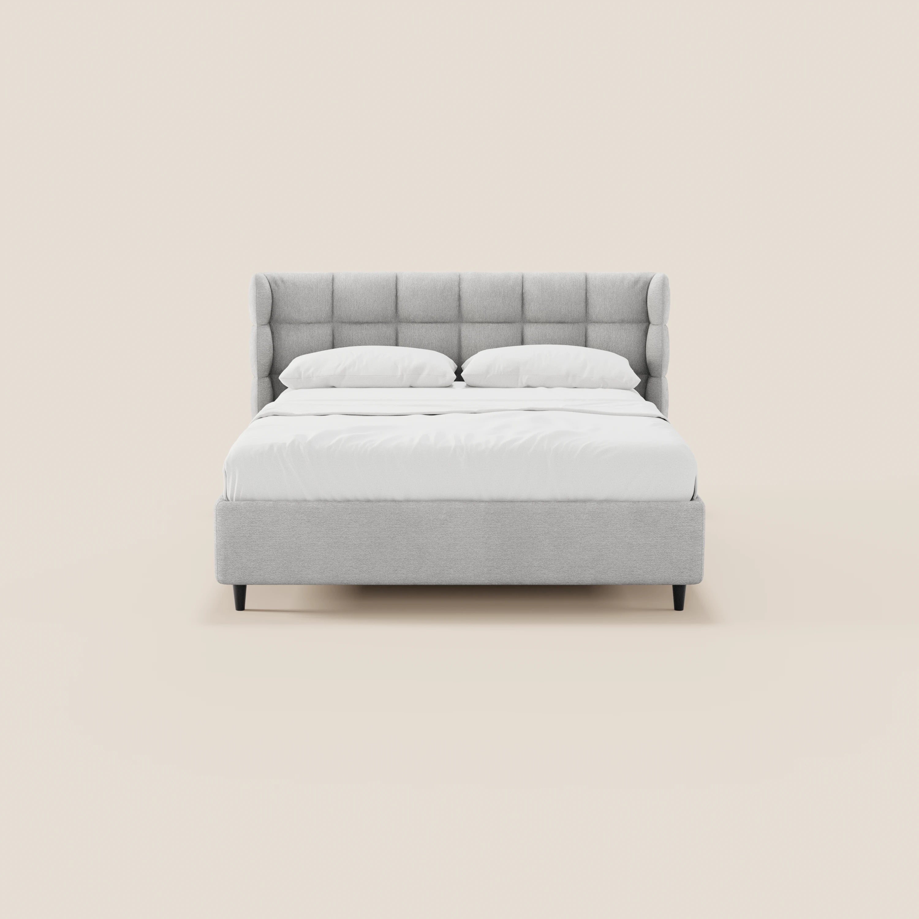 Il letto imbottito RAGNAR di Letti.store è realizzato con un tessuto grigio chiaro certificato Oeko-Tex®, testiera capitonné avvolgente, gambe nere, due cuscini bianchi e biancheria da letto. Nell’immagine è raffigurato di fronte su uno sfondo beige, con un design pulito e minimalista.