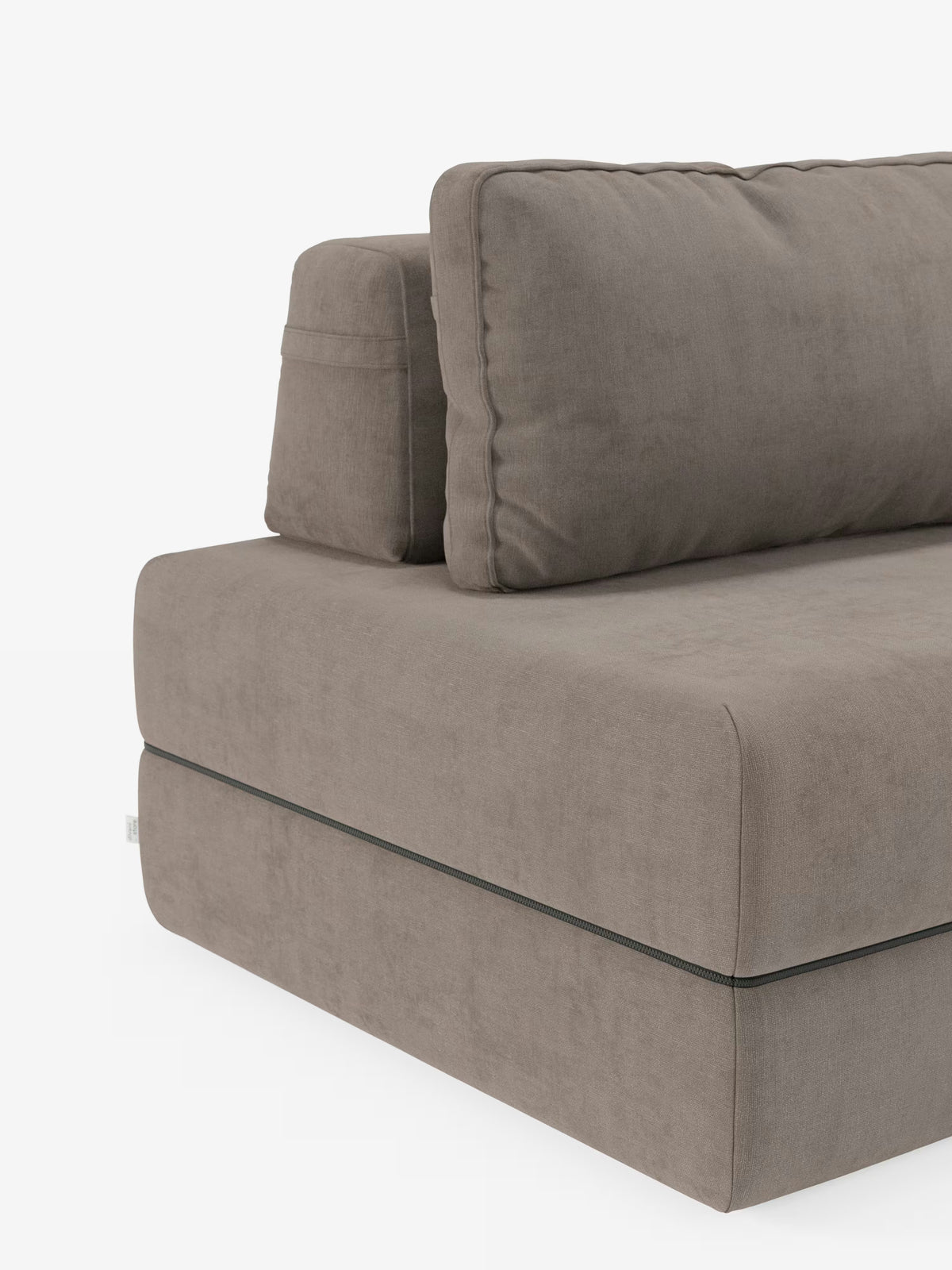 Un primo piano della poltrona letto Divani.Store Rift, con materasso alto 24 cm e memory foam, ne mette in risalto il design moderno, in tonalità marrone chiaro, caratterizzato da morbidi cuscini e da uno stile minimalista. Il morbido tessuto T31 resistente alle macchie e le caratteristiche cuciture in evidenza vicino alla base ne sottolineano la raffinata lavorazione artigianale. Dotata di schienale reclinabile, questa poltrona letto offre stile e versatilità, in risalto su uno sfondo bianco a tinta unita.