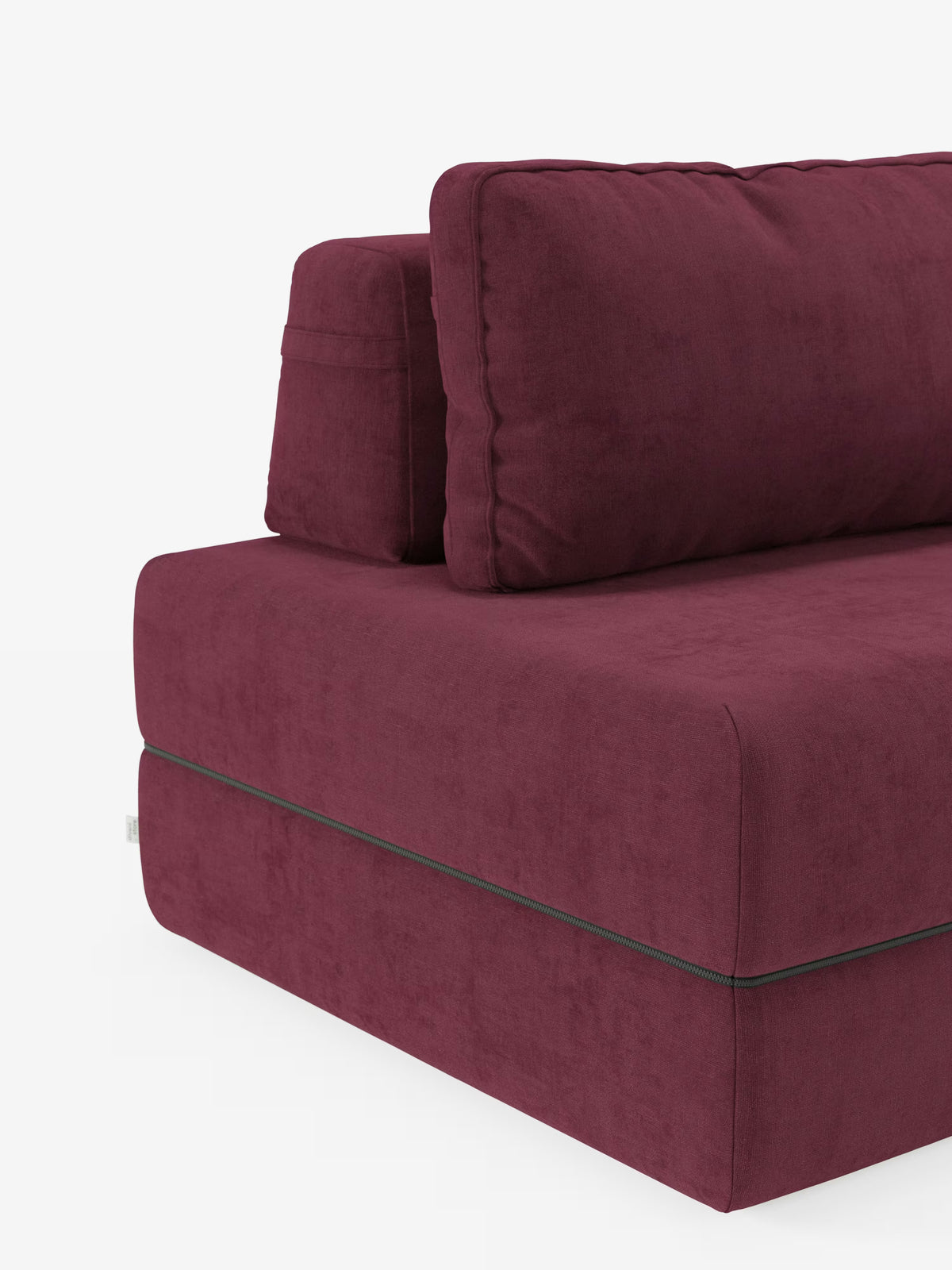 Un primo piano della poltrona letto Rift con materasso alto 24 cm e memory foam di Divani.Store ne mette in risalto il design sofisticato, rivestita in tessuto T31 smacchiabile color bordeaux intenso. L'immagine si concentra sul lato sinistro, rivelando cuscini della seduta e dello schienale rigidi e squadrati con schienale mobile, linee pulite e cuciture visibili e precise. La silhouette minimalista risalta su uno sfondo bianco a tinta unita.