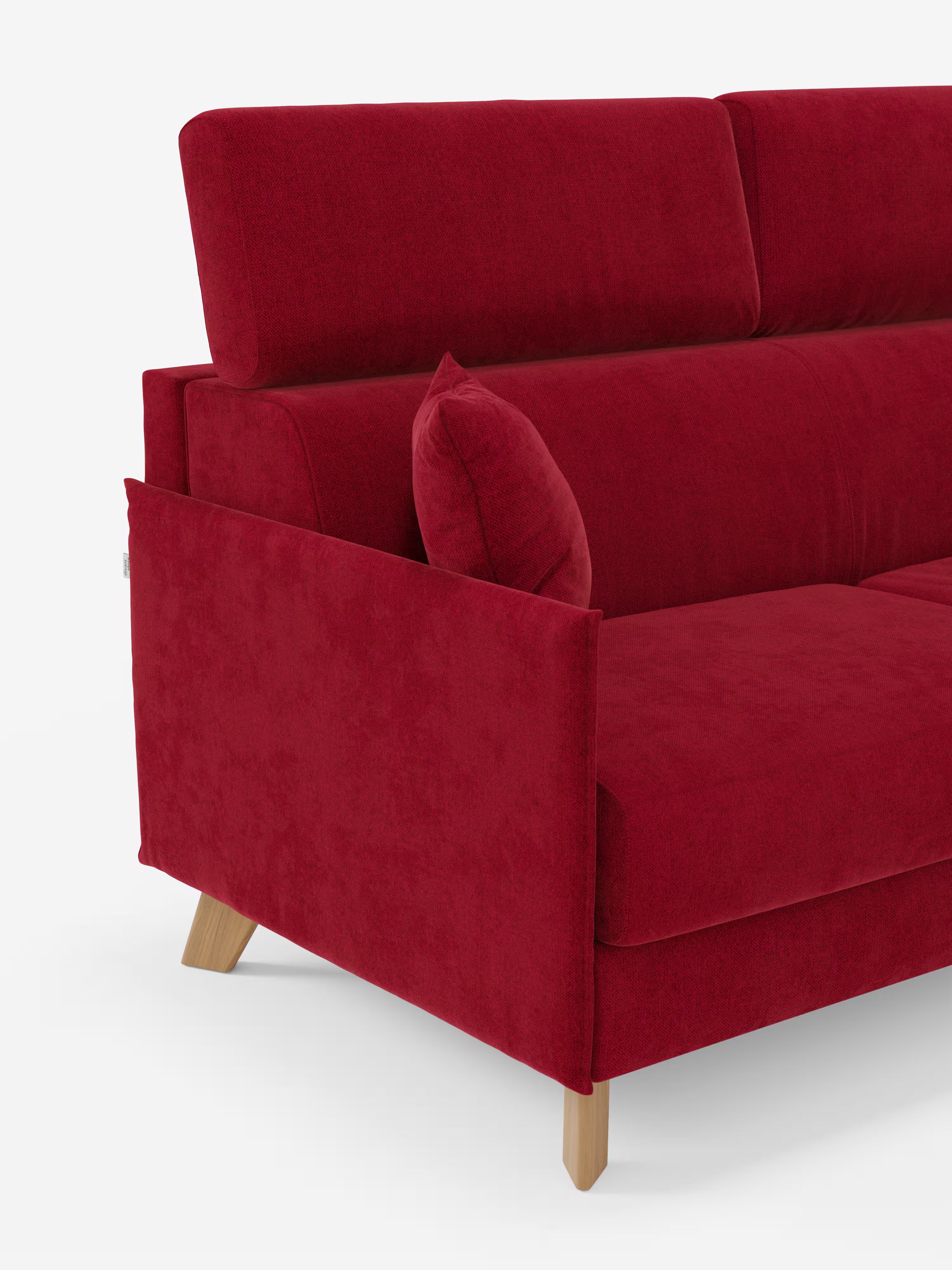Un divano letto matrimoniale contemporaneo modello "Sole" di Divani.Store, in colore rosso, è caratterizzato da morbidi cuscini, gambe in legno inclinate e poggiatesta reclinabili. Un cuscino decorativo abbinato è appoggiato sul bracciolo. Lo sfondo è bianco a tinta unita.