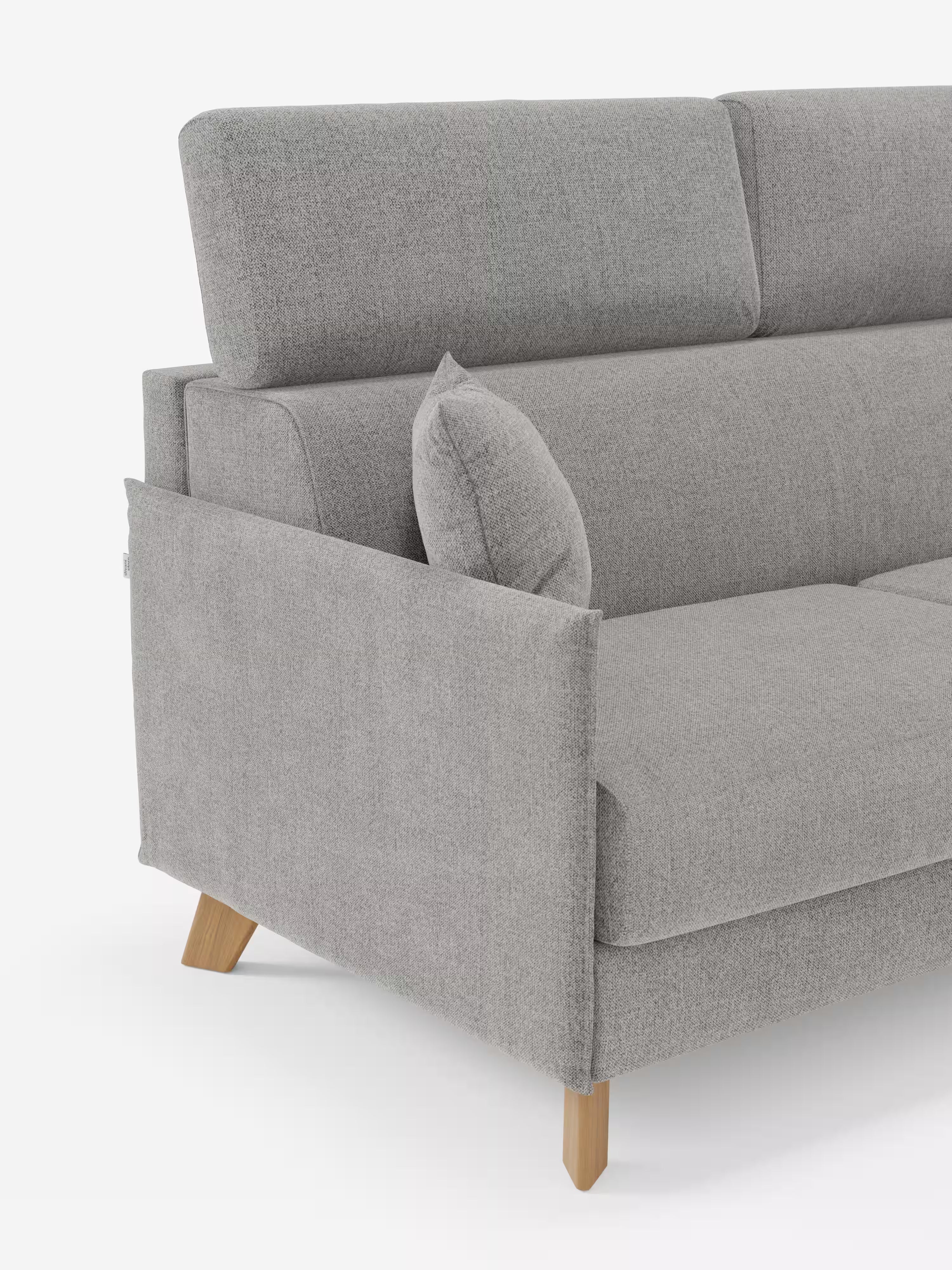 Primo piano del divano letto matrimoniale Sole dal design compatto di Divani.Store, realizzato in moderno tessuto grigio chiaro, con poggiatesta reclinabili, un cuscino coordinato e gambe angolate in legno. I braccioli e la seduta presentano linee pulite e un look minimalista ispirato allo stile scandinavo. Il divano è sfoderabile al 100% in tessuto smacchiabile T23, su uno sfondo bianco a tinta unita.