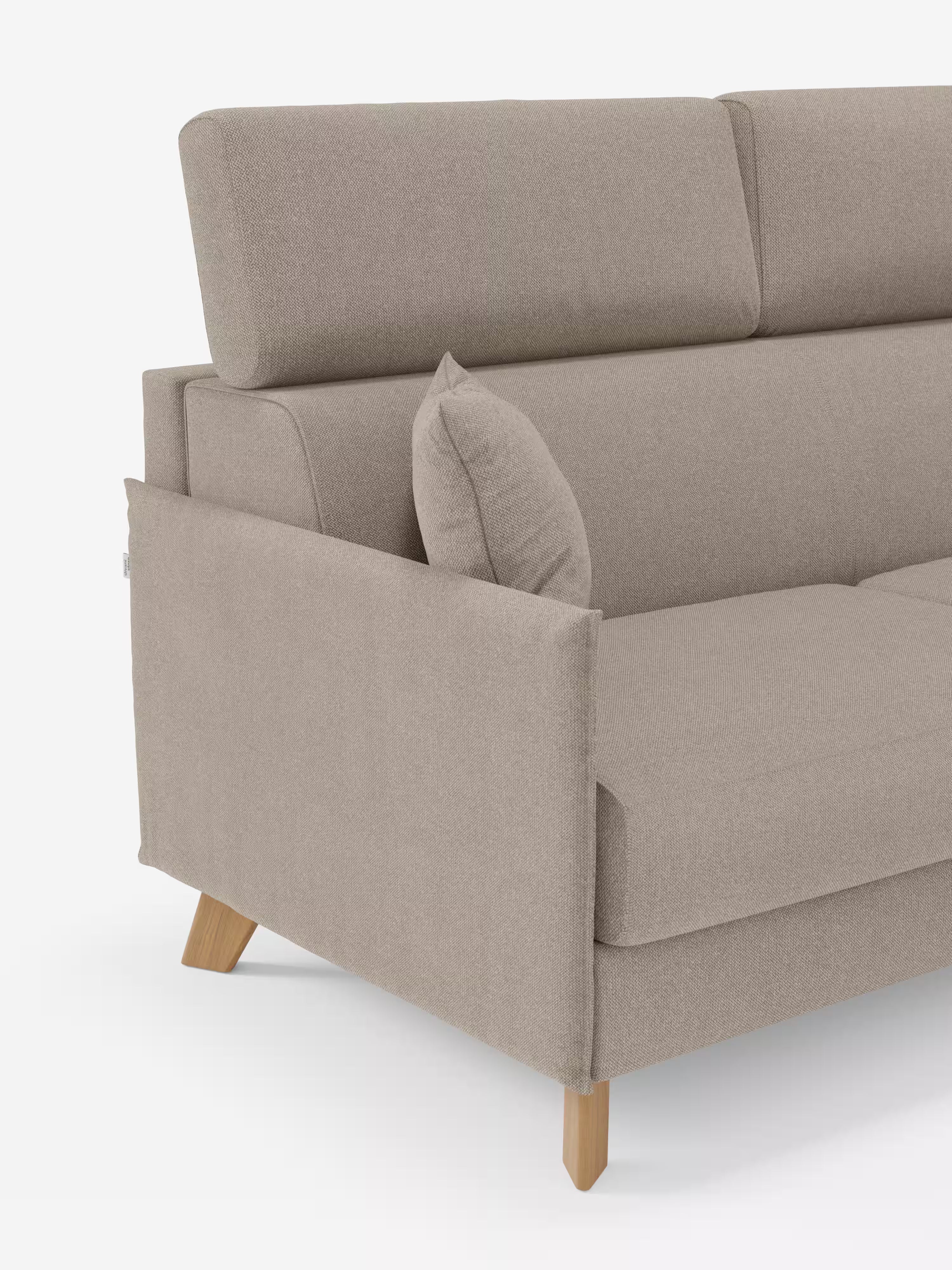 Un divano letto matrimoniale "Sole" color beige di Divani.Store, caratterizzato da un design moderno e compatto con gambe angolari in legno, poggiatesta reclinabili, linee pulite e un cuscino coordinato sul bracciolo in tessuto T23 antimacchia, è ripreso su uno sfondo bianco. Nell’immagine è visibile solo l’estremità sinistra di questo divano letto con rivestimento sfoderabile al 100%.