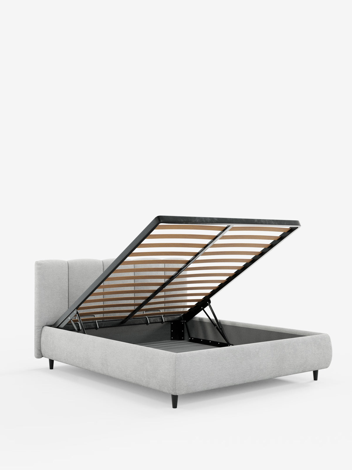 Il modello ARKAM, letto imbottito con contenitore e testiera a lavorazione verticale di Letti.store, è un moderno letto contenitore imbottito di colore grigio chiaro, realizzato in tessuto certificato Oeko-Tex®, raffigurato con la rete a doghe parzialmente sollevata che rivela un ampio spazio contenitore al di sotto. Questo modello in stile shabby chic presenta una testiera alta e imbottita con dettagli verticali e poggia su gambe corte e affusolate di colore nero, che risaltano sullo sfondo bianco a tinta