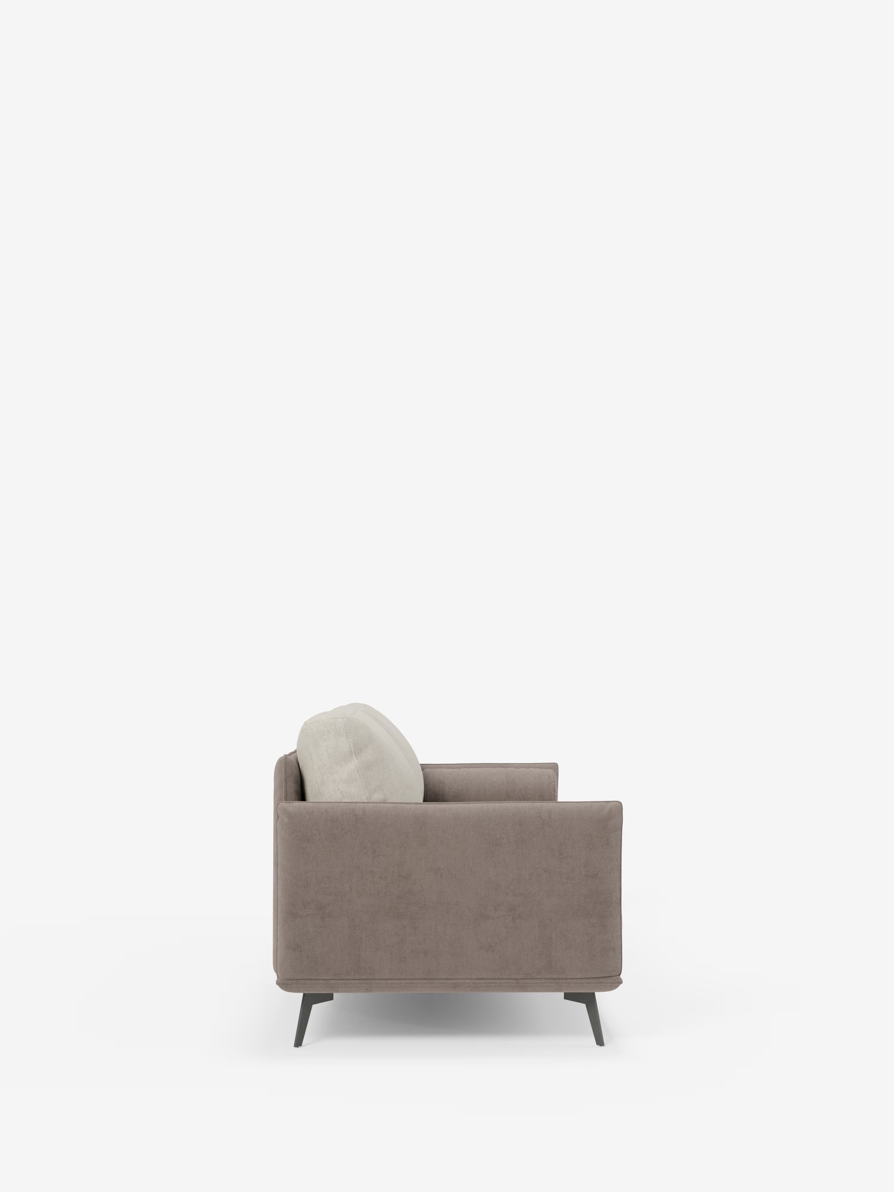 Vista laterale del divano Basalto a 2 o 3 posti bicolore di Divani.Store: un divano moderno caratterizzato da un unico cuscino beige chiaro appoggiato allo schienale. Questo modello contemporaneo presenta una seduta esclusiva in tessuto T31 di facile pulizia, braccioli dritti, linee pulite e poggia su quattro gambe corte e angolate in metallo scuro. Gli schienali sono imbottiti in piuma d’oca per un maggiore comfort. Lo sfondo è bianco a tinta unita.