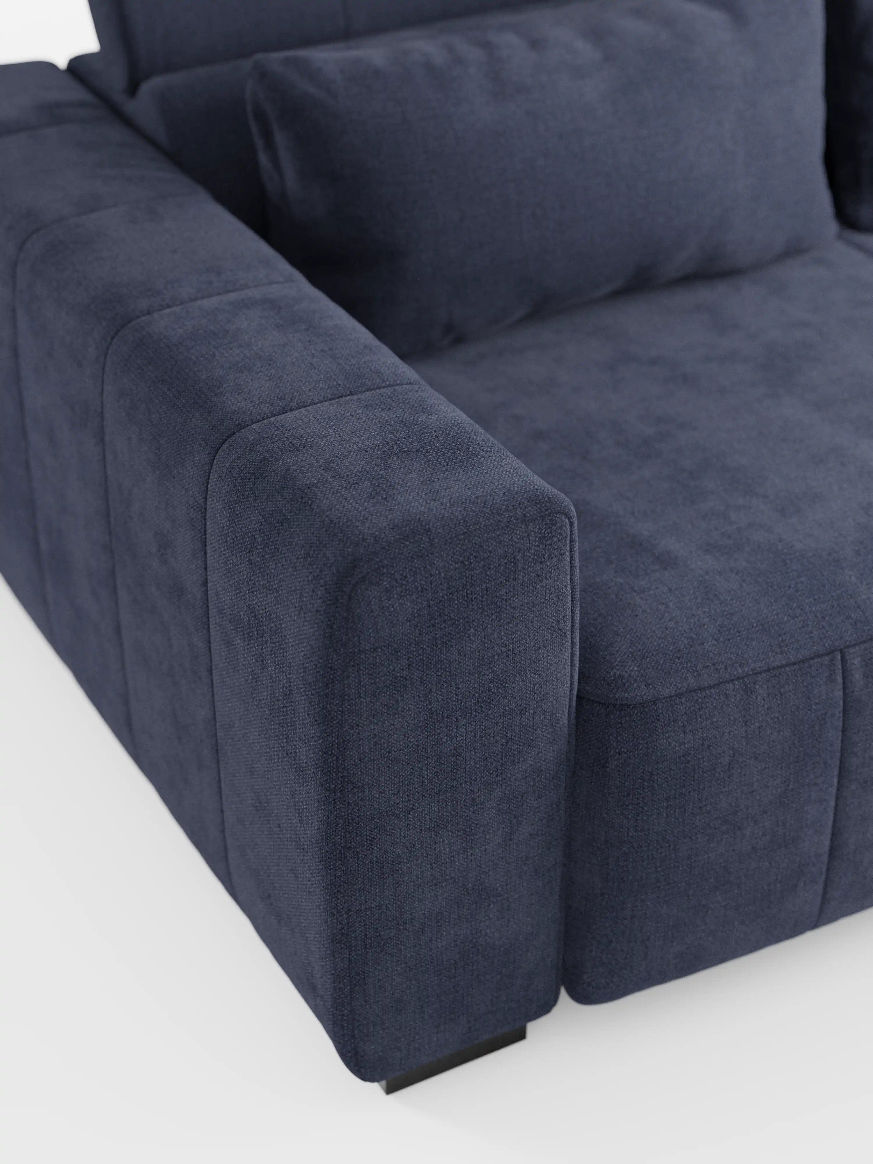 Primo piano del divano a 3 posti Doric di Divani.Store, caratterizzato da un moderno rivestimento in tessuto T23 blu navy resistente alle macchie, morbidi cuscini coordinati, braccioli rettangolari e un poggiatesta reclinabile. Di questo divano contemporaneo con sedute reclinabili elettriche è visibile solo un angolo, su uno sfondo bianco.