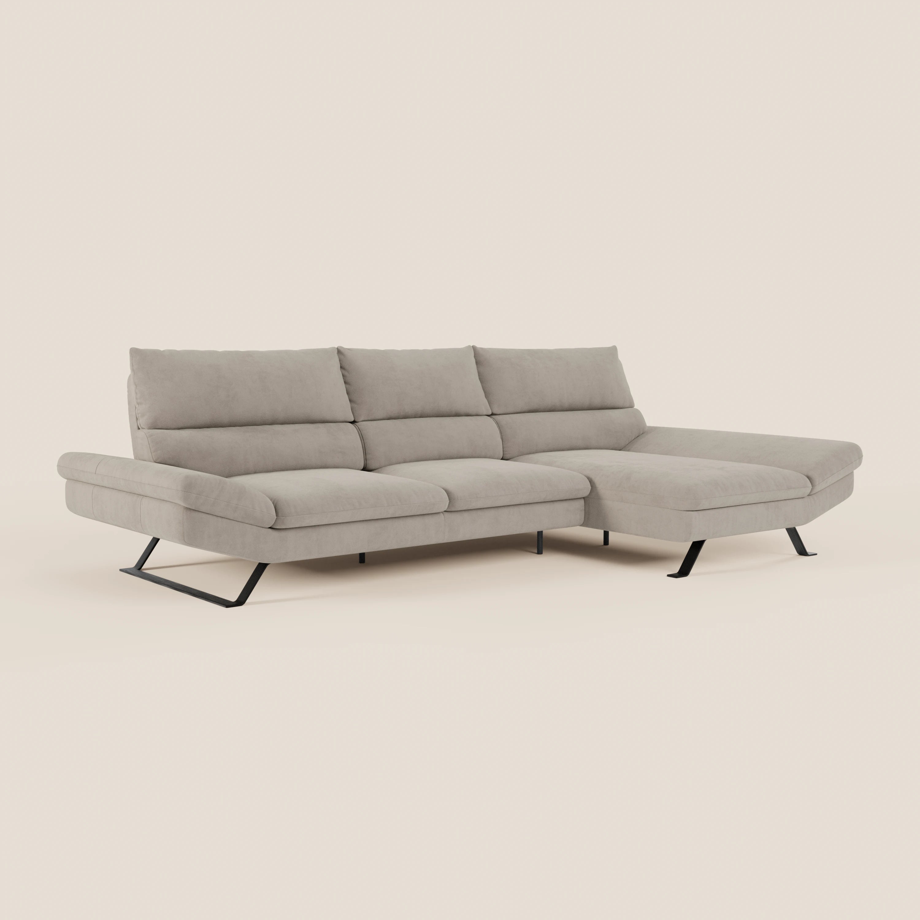 Il Divano Eclipse angolare con penisola e schienali traslanti T11 di Divani.Store in microfibra tecnica beige chiaro è caratterizzato da tre cuscini di schienale, ampie sedute, chaise longue destra e gambe angolari in metallo nero su sfondo chiaro.