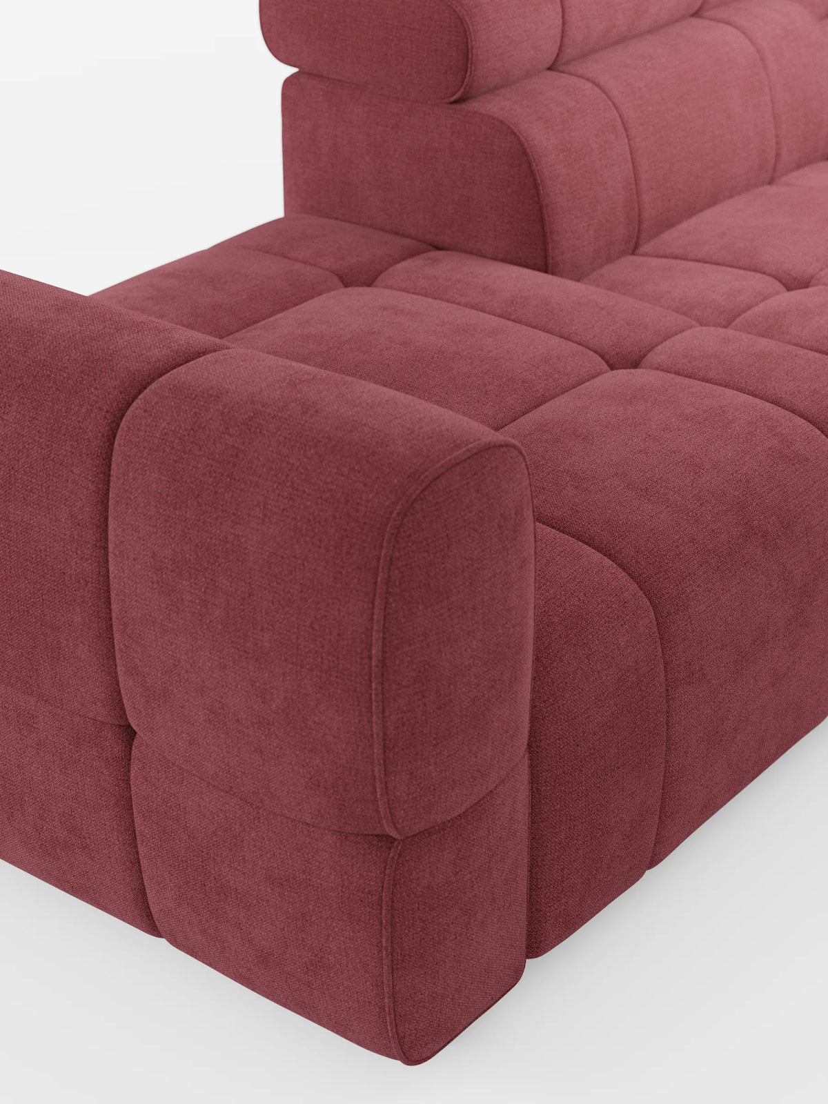 Una vista dall'alto del divano componibile Giotto con terminale aperto – opzione relax elettrico in tessuto smacchiabile T23 color rosso bacca intenso, caratterizzato da un motivo trapuntato a griglia sui cuscini quadrati e da braccioli spessi e arrotondati.