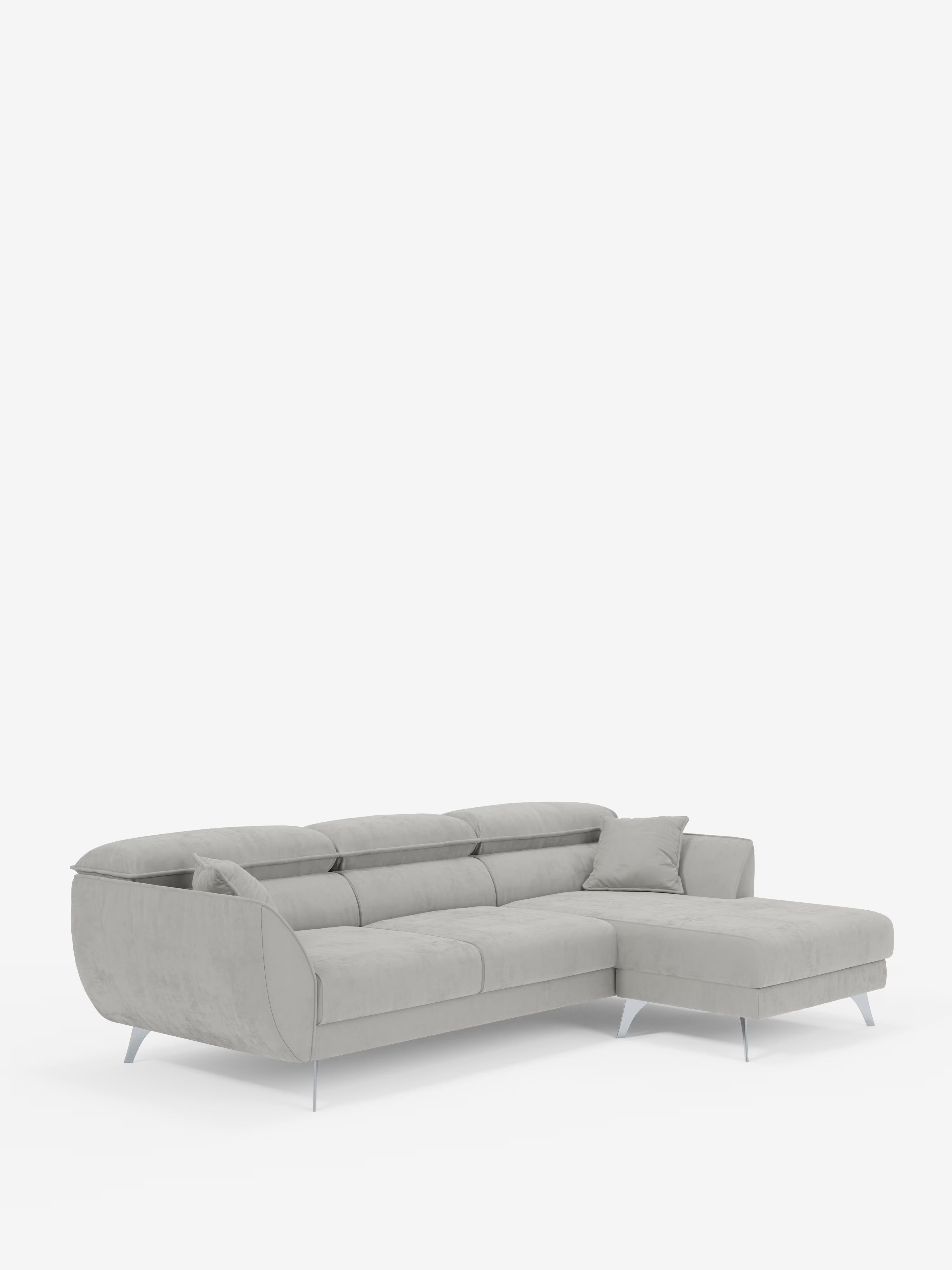 Il divano angolare con penisola e sedute estensibili Michelangelo di Divani.Store è un divano componibile a forma di L di colore grigio chiaro, realizzato in un elegante tessuto smacchiabile effetto vellutino T30. È caratterizzato da sedute imbottite dal profilo ribassato, ampi braccioli, cuscini coordinati e sottili gambe argentate che gli conferiscono un aspetto sofisticato. I poggiatesta reclinabili ne aumentano il comfort e la versatilità. Il divano è presentato su uno sfondo bianco a tinta unita.
