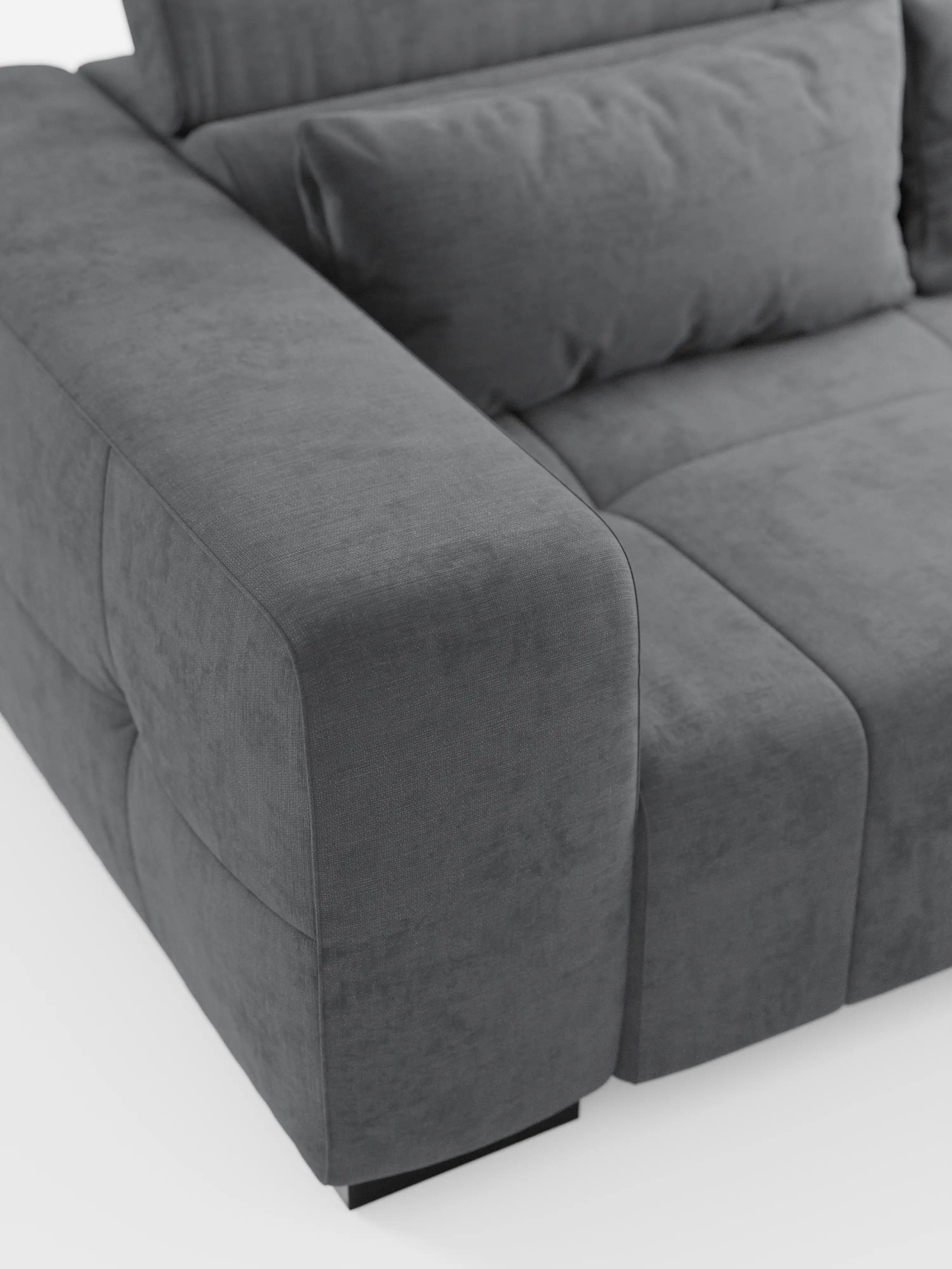 Un primo piano del divano Monarch con relax elettrico per l'allungamento delle sedute e poggiatesta reclinabile di Divani.Store, caratterizzato da braccioli spessi, cuscini morbidi e un rivestimento in tessuto T31 morbido e resistente alle macchie, con cuciture discrete. Il moderno divano grigio scuro poggia su piccoli piedini neri su uno sfondo bianco a tinta unita, che ne accentua le linee pulite e la finitura testurizzata.
